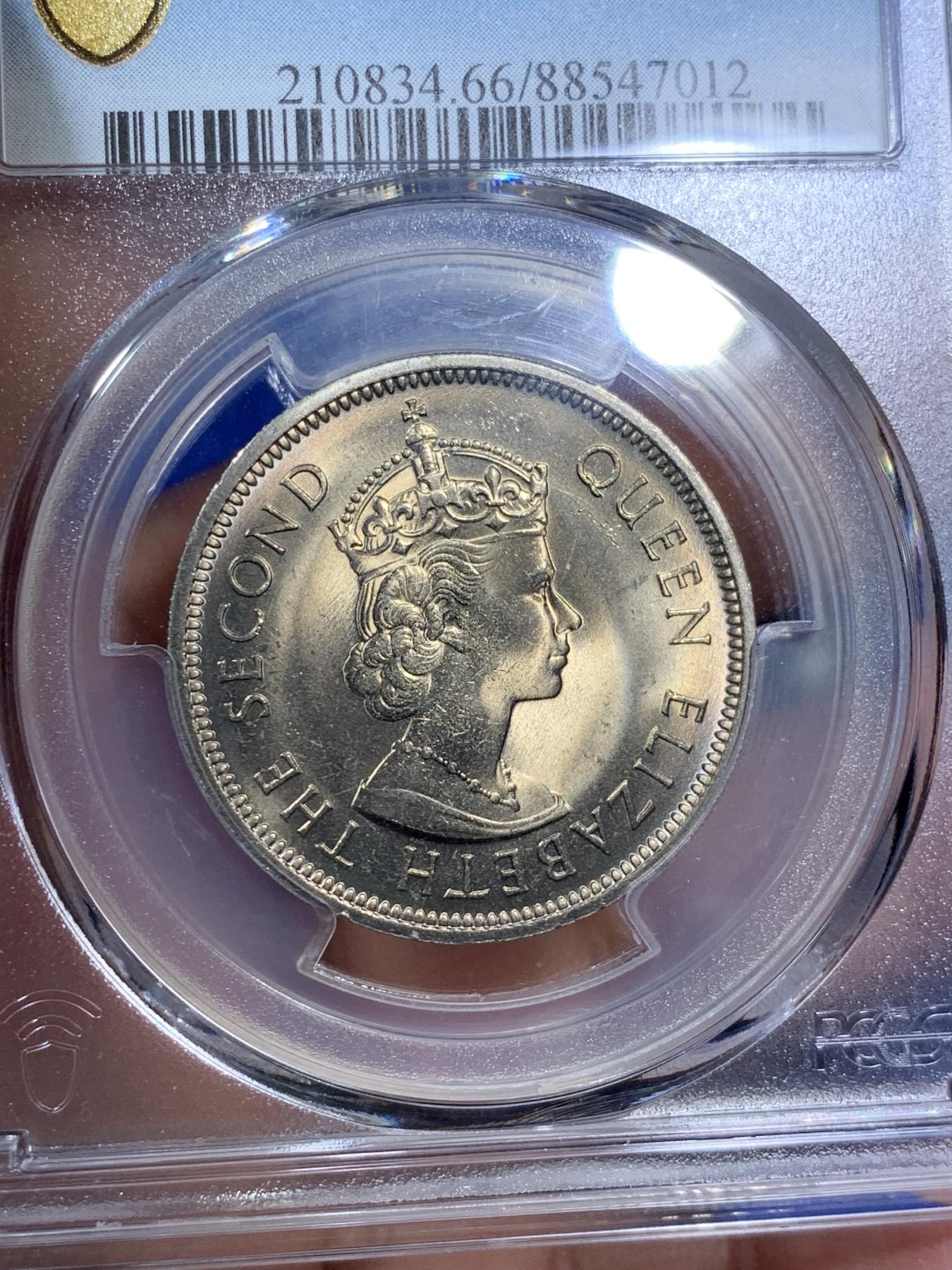 《竞宝斋》第270场- 周日，周一，周二  3场连拍 （全场包邮） PCGS MS66 香港1973年伊丽莎白二世1元大饼 铸造时压力给的过分的充足，头像周围金属被挤压像湖面的涟漪一样扩散，轻微氧化下呈现少见的镍币黄油彩，深色部分呈现桔红色，一卷中最好的即可。
