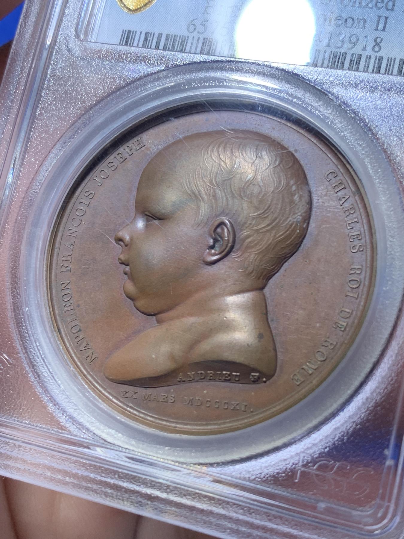 《竞宝斋》第270场- 周日，周一，周二  3场连拍 （全场包邮） PCGS SP65 唯一冠军分 法国1811拿破仑罗马王原铸铜章 纪念拿破仑之子罗马王诞生 堪称拿破仑一家三口宫廷肖像画 一面是拿破仑和妻子路易丝王后头像 另一面拿破仑二世圆滚滚婴孩可爱形象 与哈布斯堡王朝联姻的血脉 为比肩古罗马帝国 拿破仑授予儿子