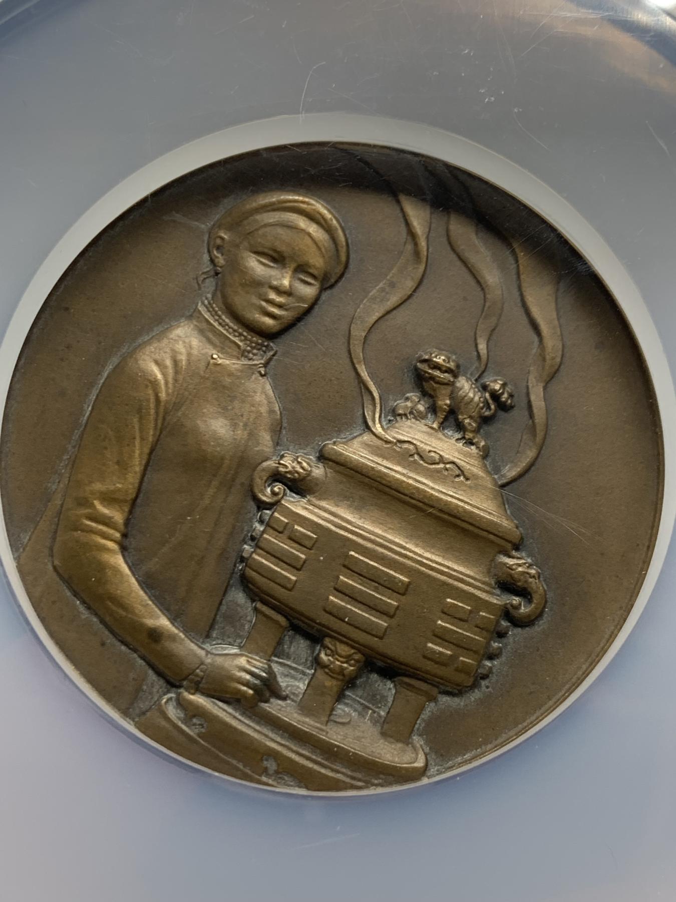 《竞宝斋》第272场- 周日，周一，周二  3场连拍 （全场包邮） NGC-MS63BN 法属安南1931年殖民博览会大铜章 正面身穿传统奥黛女子手扶袅袅升烟的八卦大香炉 背面凤鸟与东京，东京为越南北部旧称， 60毫米,102.5克 大盒封装