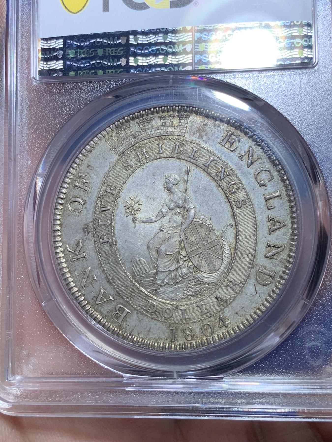 《竞宝斋》第272场- 周日，周一，周二  3场连拍 （全场包邮） PCGS MS62 英国1804乔治三世英格兰银行五先令银币 通体原味深彩包浆 深打 底板的双柱币胚依稀可见 底板丝滑 比一般的62感官上好一些