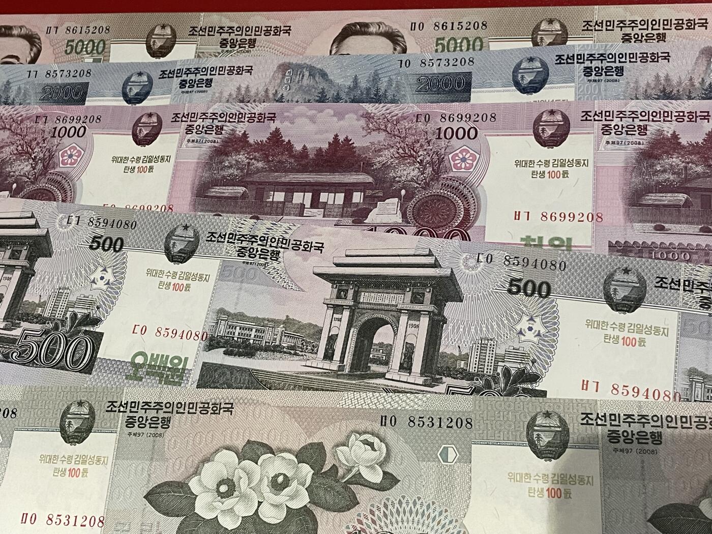 世界各国纸币、朝鲜钞、连体钞、测试钞、套币等专场 【第5场】 金日成诞辰100周年纪念连体钞 一套带原筒，含证书（筒有折痕） 【含2002年5、10、50元24连体、2008年100-5000元28连体】共9张全套连体钞。全新UNC