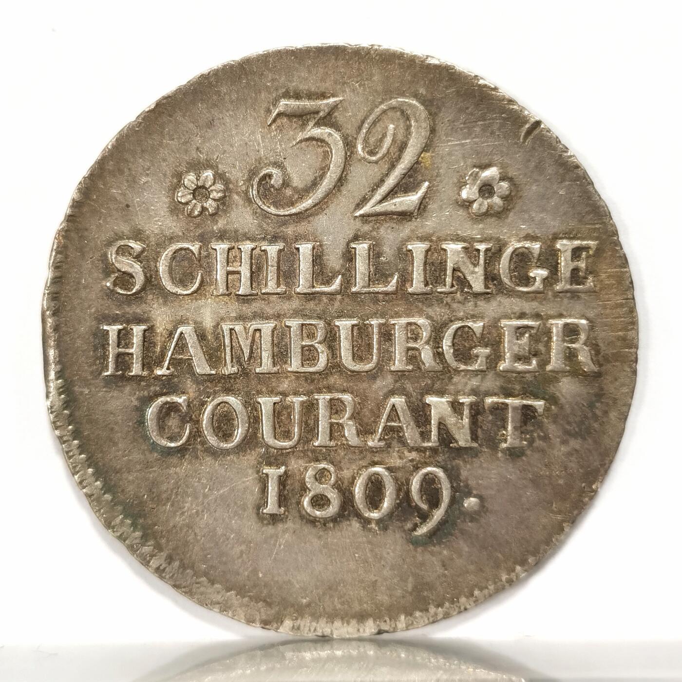 【麦稀奇世界钱币展】博洋堂“流萤染夏”六月精品专场暨第081期（全场包邮） 1809年德国汉堡市32先令银币 拿破仑法国达武元帅发行的围城币 包浆彩色十分漂亮 纹章繁复精美 1814年汉堡并入拿破仑法国领土 驻守汉堡的达武元帅被反法联军包围 夺取汉堡银行的存银 用1809年模具生产围城币 只把签名改成法国负责人CAJG