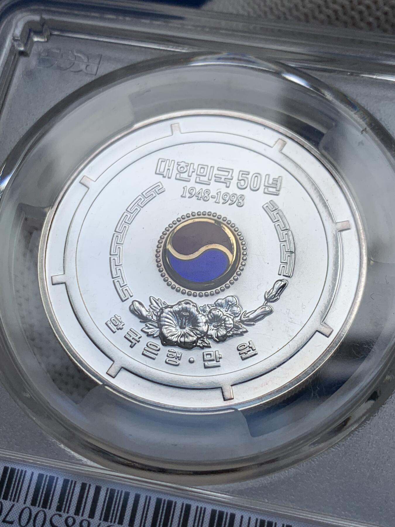 《竞宝斋》第279场- 周日，周一 ，周二3场连拍 （全场包邮） PCGS MS69 少见韩国银币 附带原包装和证书 1998韩国10000韩元 建国50周年纪念银币 中间有珐琅彩 有点致敬朝鲜大东珐琅的意味 这一枚是P盒唯一冠军分 珐琅彩很难保存 工艺非常好 币面极干净
