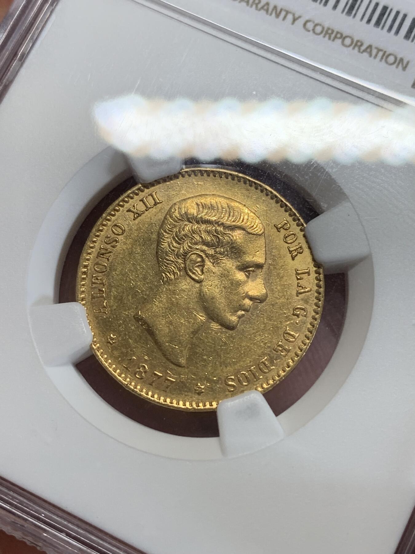 《竞宝斋》第279场- 周日，周一 ，周二3场连拍 （全场包邮） NGC AU58 西班牙 1877年 阿方索十二世25比塞塔金币 8.07克 90%金 金光满溢，铸打深峻，人像肌理真实，状态姣好。阿方索十二世是波旁王朝的西班牙国王（1874年-1885年在位），出生于马德里，是西班牙女王伊丽莎贝二世之子