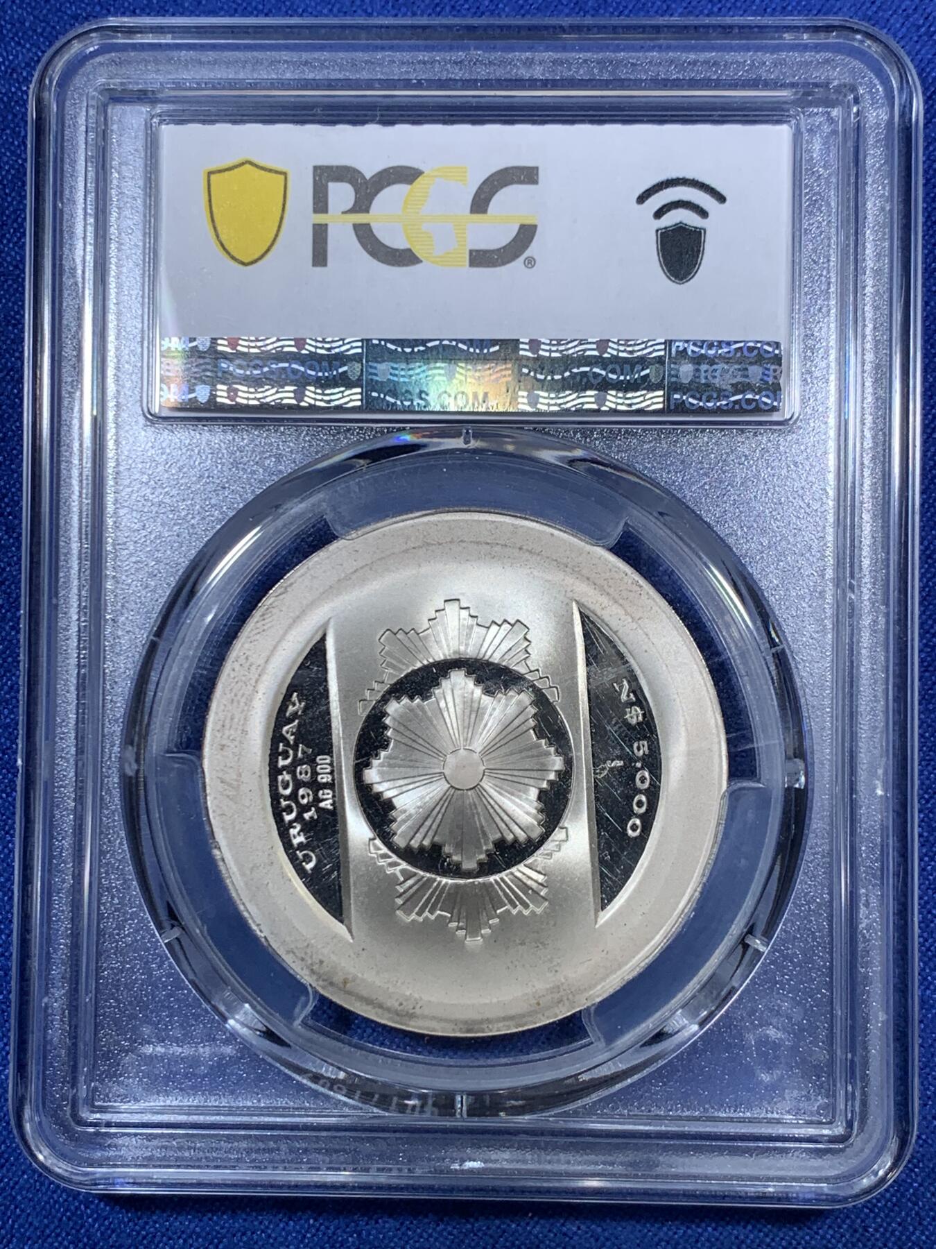 《竞宝斋》第280场- 周日，周一 ，周二3场连拍 （全场包邮） PCGS PR68DCAM 1987乌拉圭5000比索 中央银行成立20周年纪念 精制银币 发行量非常少 设计非常有未来感 简洁但又不简单 非常特别的一枚 币面主要都是凝霜部分 保存非常不易