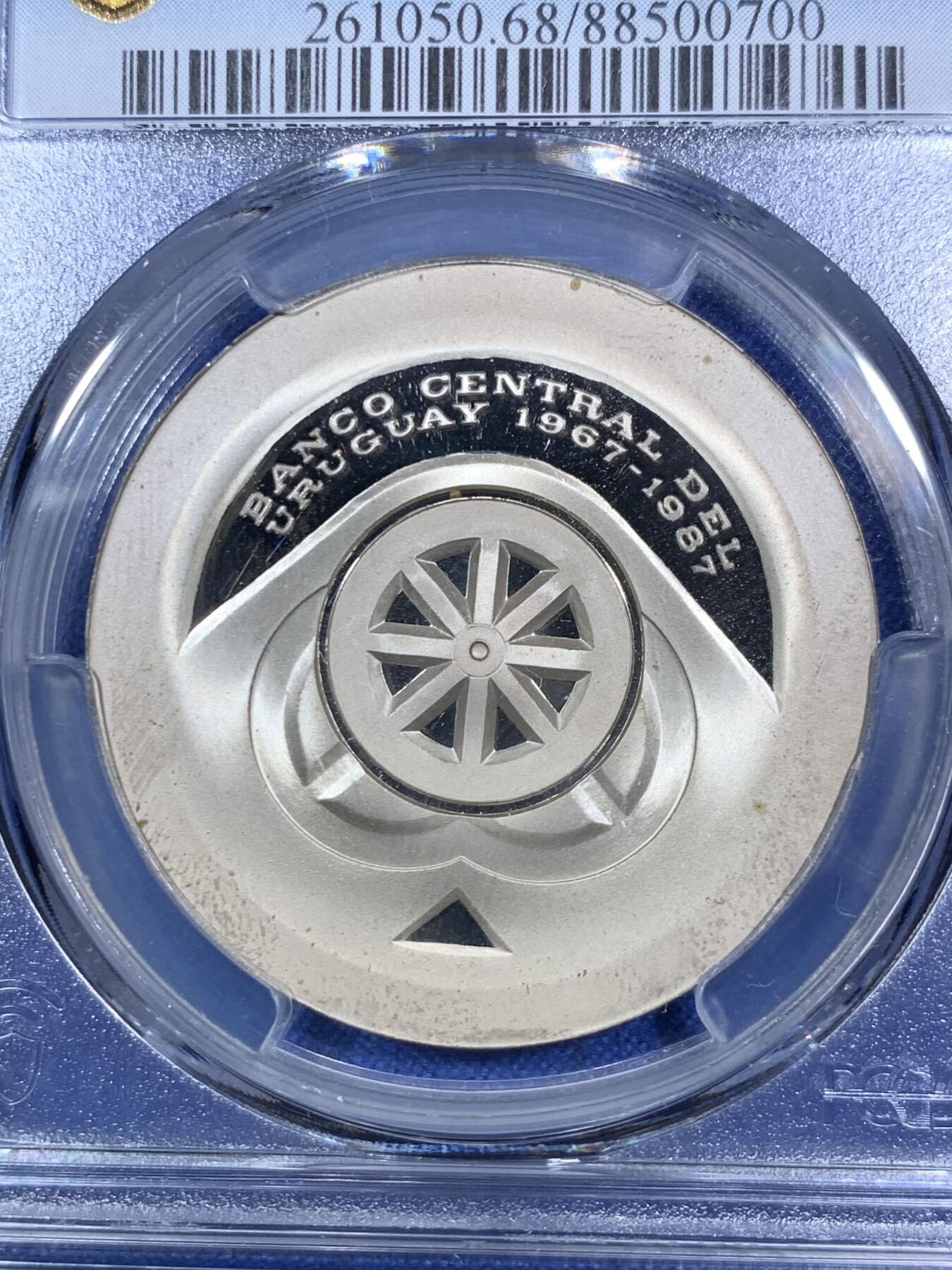 《竞宝斋》第280场- 周日，周一 ，周二3场连拍 （全场包邮） PCGS PR68DCAM 1987乌拉圭5000比索 中央银行成立20周年纪念 精制银币 发行量非常少 设计非常有未来感 简洁但又不简单 非常特别的一枚 币面主要都是凝霜部分 保存非常不易