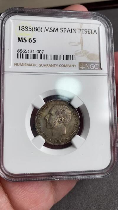 万国钱币拍卖第028期（花前月下●同享良章美币） NGC MS65 1885年西班牙阿方索十二世1比塞塔银币 欧洲包浆完全体 肉眼无法挑出毛病的一枚 HA拍卖原物 原PC老白盒66分砸盒 十几年前的成交价就超过1700美金。
