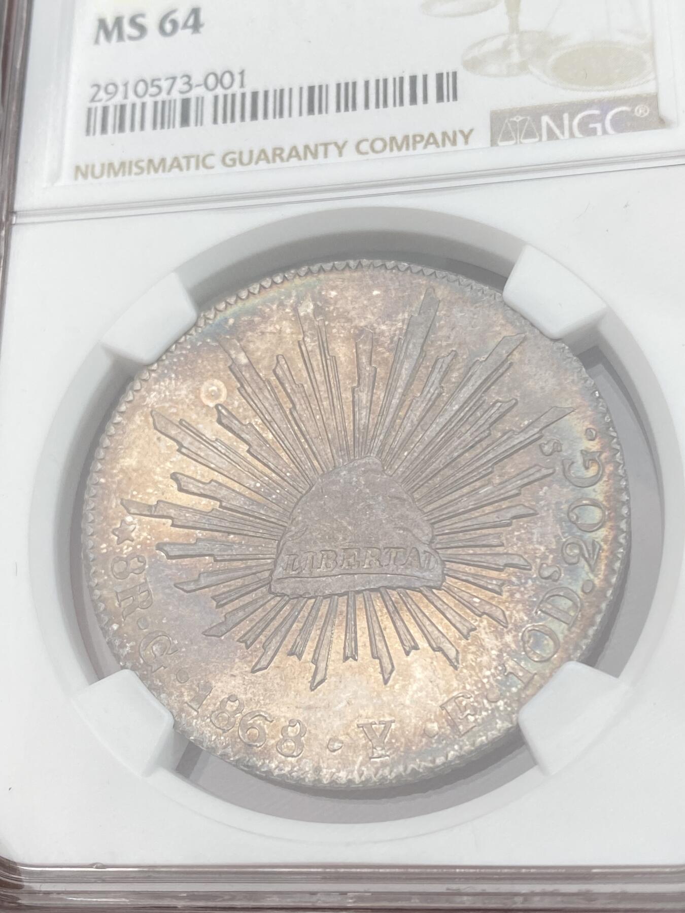 万国钱币拍卖第028期（花前月下●同享良章美币） NGC MS64 1868年墨西哥鹰洋8R银币 梦幻彩虹包浆，实物绝美。底板和打制都是64分中的佼佼者。老评级号换的新盒子，品质保证。