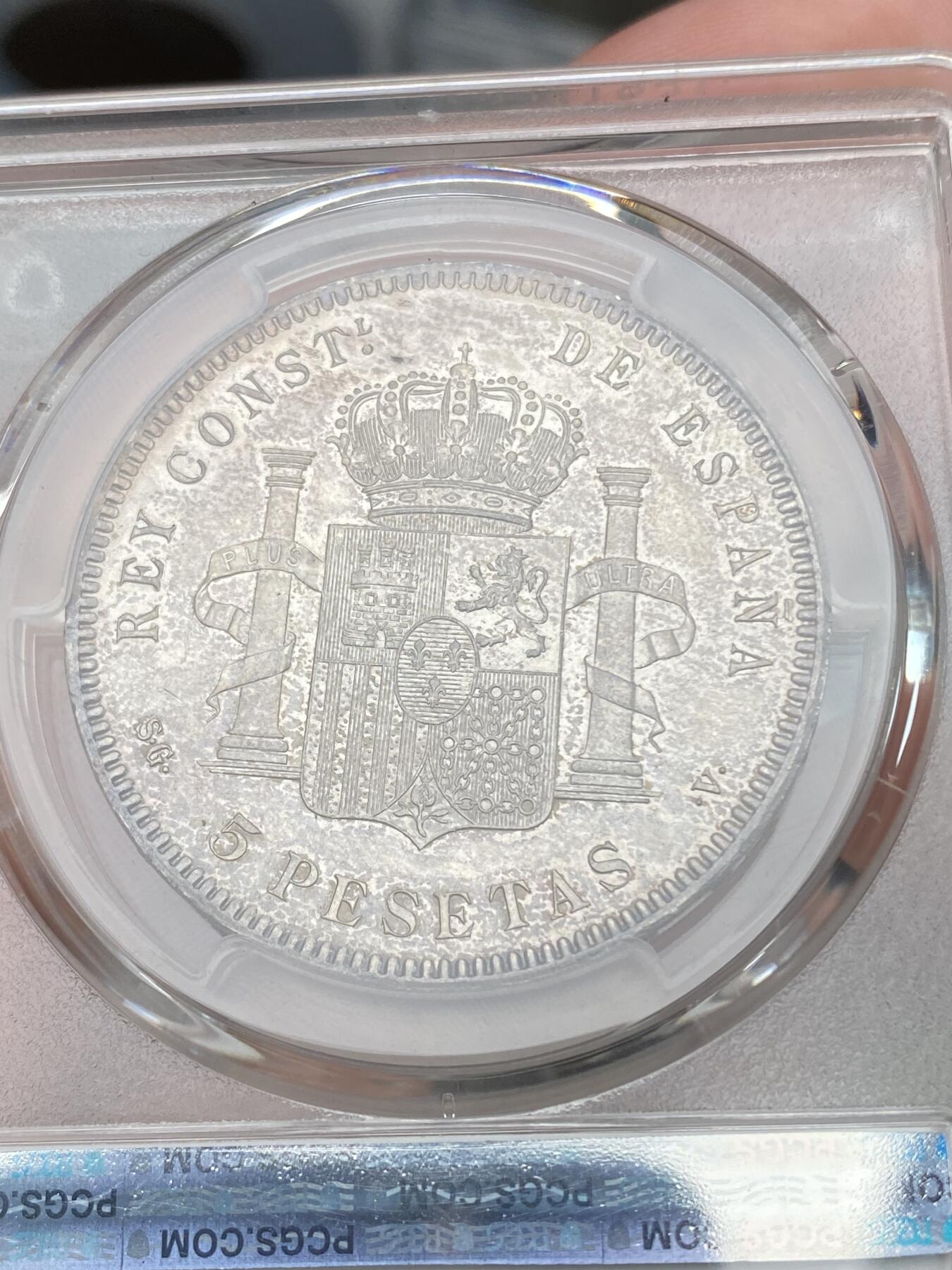 万国钱币拍卖第028期（花前月下●同享良章美币） PCGS MS63 1899年西班牙5比塞塔大银币 经典男童设计，海格力斯双柱。通体原味虹彩包浆，车轮光打制优异底板佳。实物非常漂亮，远超白板的视觉享受，也没有一般63的伤痕累累。评分略微保守，作为流通币保存状态相当不错。相对少见的年份，值得收藏的热门西班牙大银。