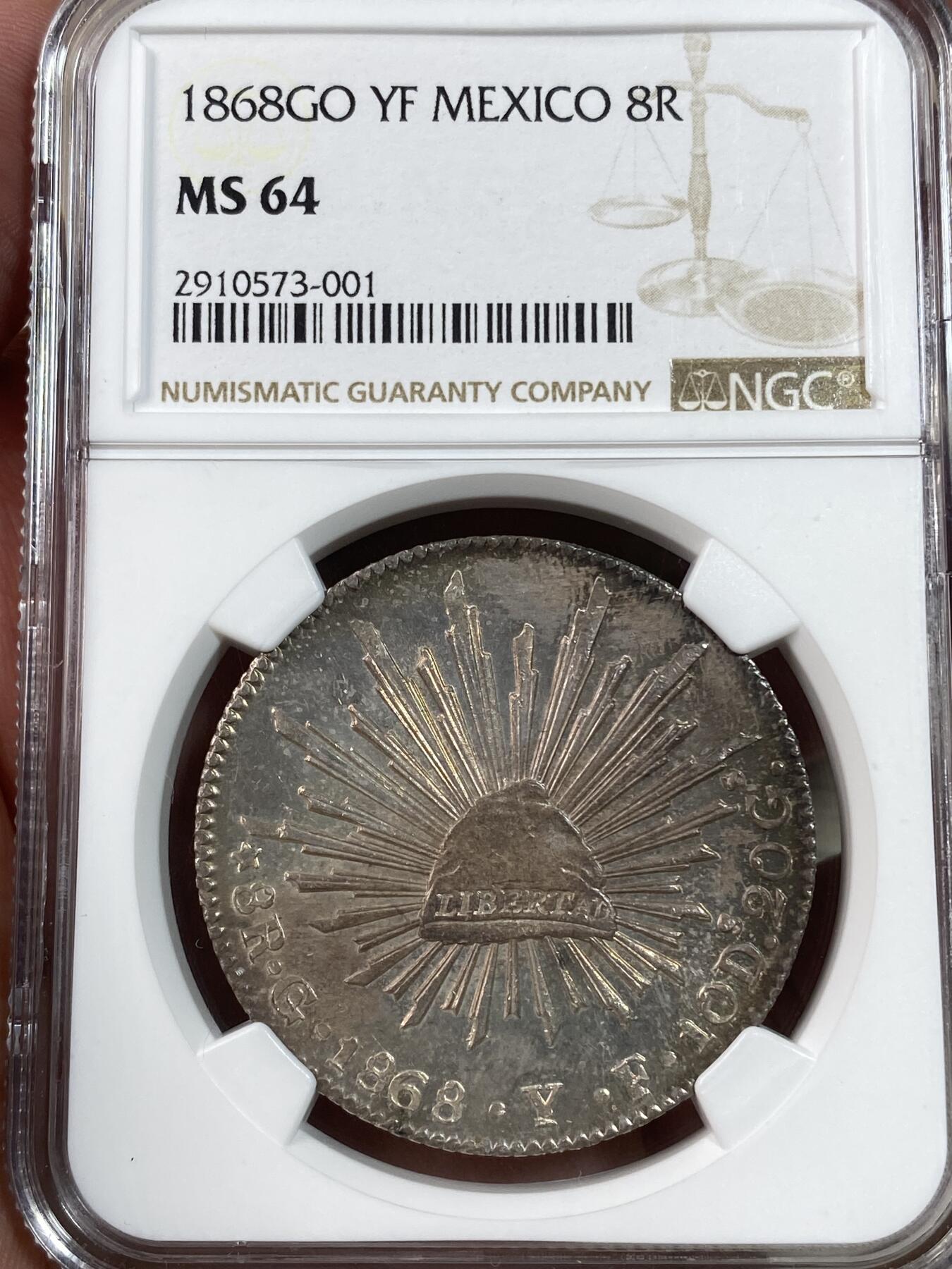 万国钱币拍卖第028期（花前月下●同享良章美币） NGC MS64 1868年墨西哥鹰洋8R银币 梦幻彩虹包浆，实物绝美。底板和打制都是64分中的佼佼者。老评级号换的新盒子，品质保证。