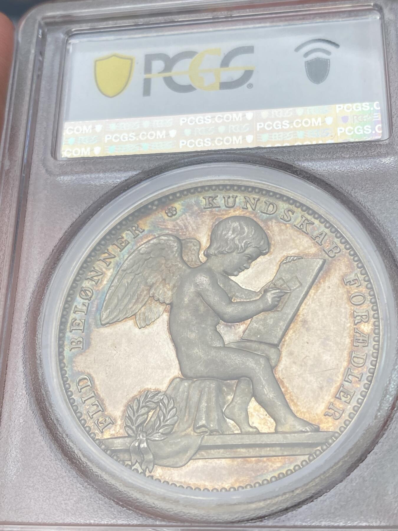 万国钱币拍卖第028期（花前月下●同享良章美币） PCGS SP63 唯一记录1887年丹麦汉斯-马斯曼主日学校银质大奖章，加厚评级盒！超厚重的北欧大银章，背面勤学的小天使图案非常可爱 。42MM 44G