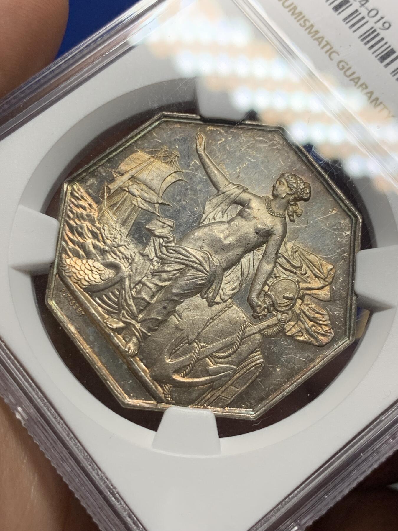 《竞宝斋》第285场- 周日，周一 2场连拍 （全场包邮） NGC MS61 法国1869年先见之明保险公司银质八角代币 名誉品 海港 优雅女神 神明庇护 出海帆船 盆满钵满的金银 36.3毫米 19.13克 蜜蜂边铭 低评 状态非常好