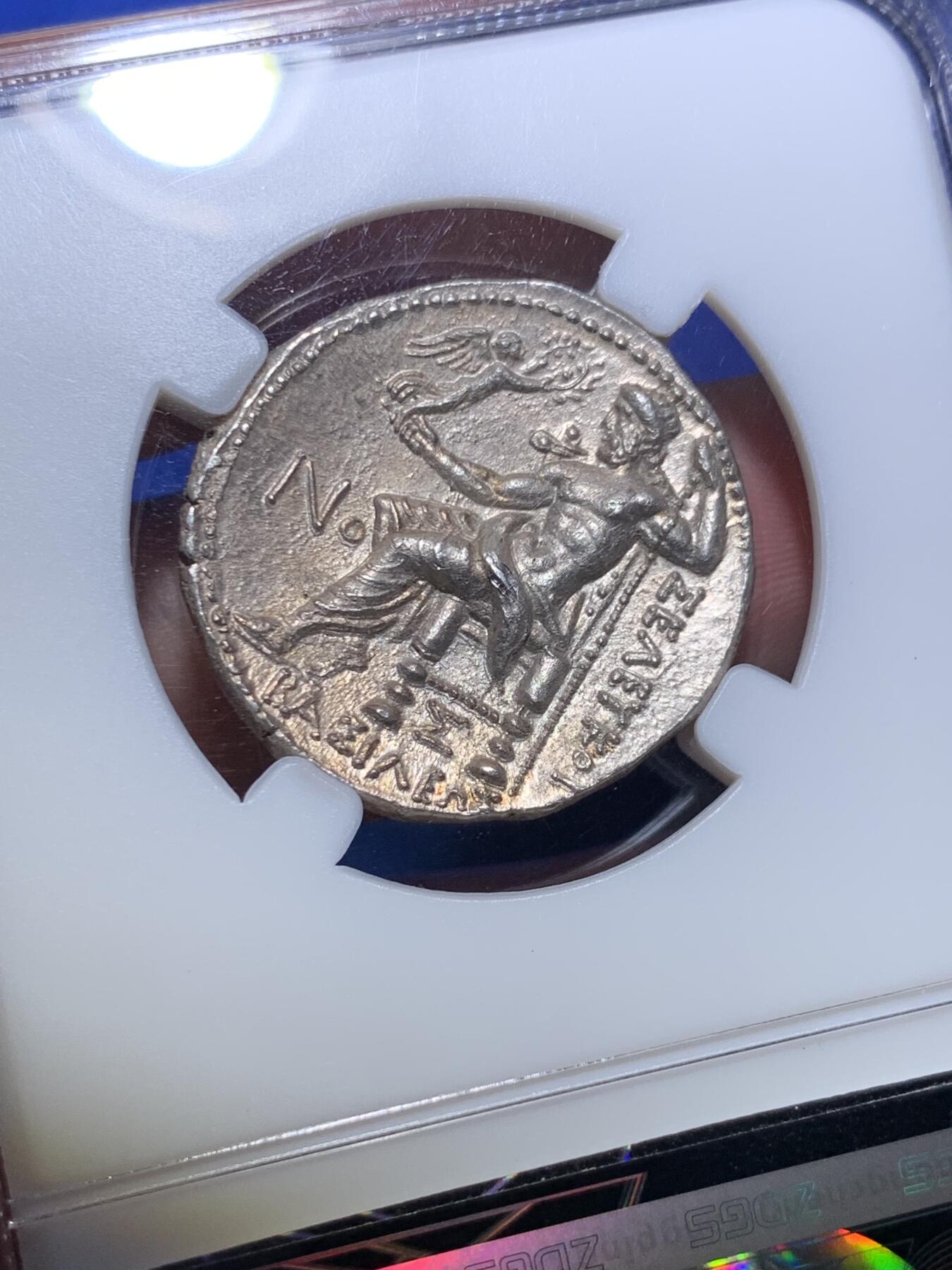 《竞宝斋》第285场- 周日，周一 2场连拍 （全场包邮） 众诚详评AU 古希腊亚历山大大帝4德大银币 极品品相原光 背面宙斯手托胜利女神NIKE 艺术感和观感极佳 惊为天人 少见的塞琉古一世铸造