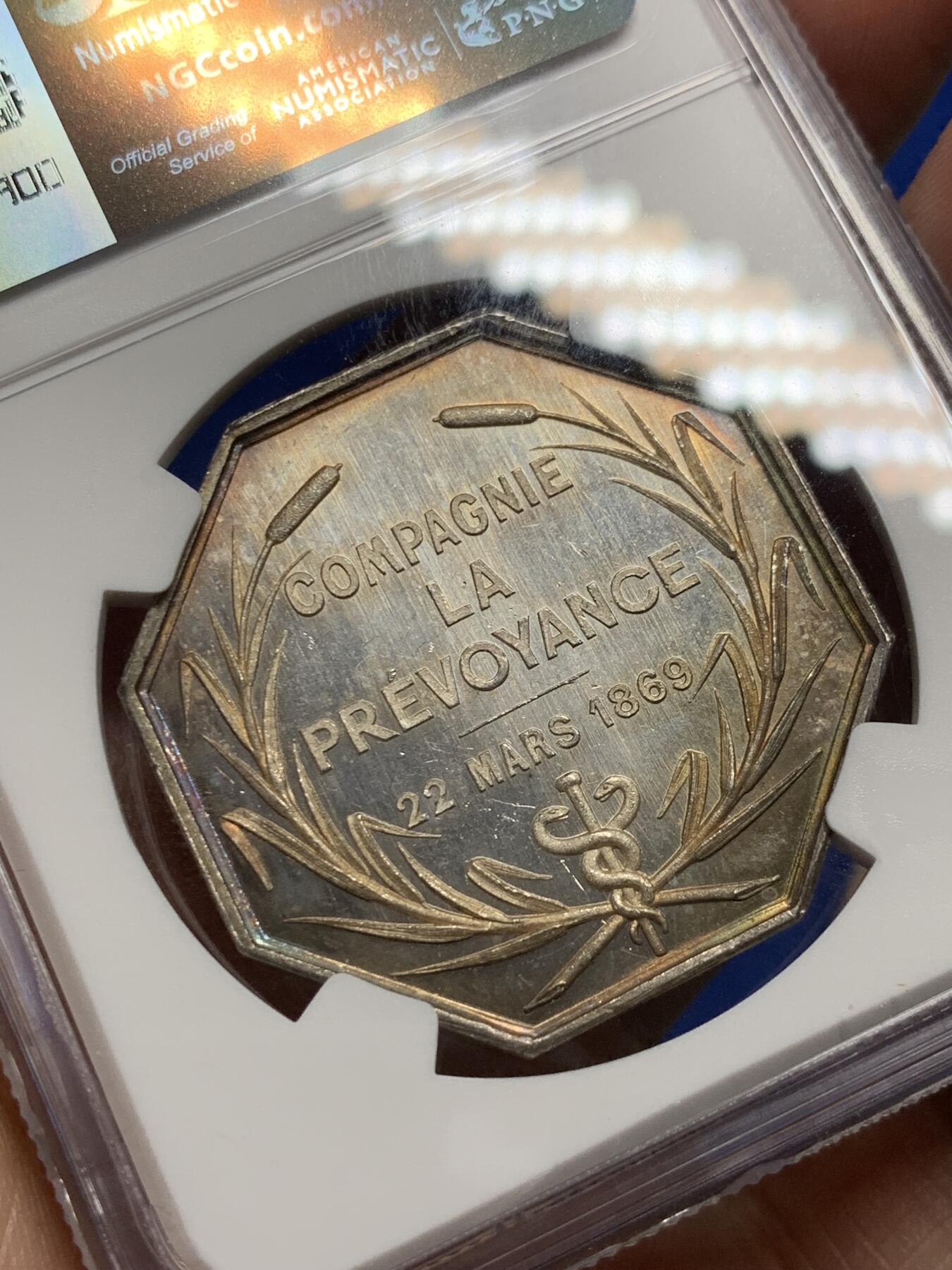 《竞宝斋》第285场- 周日，周一 2场连拍 （全场包邮） NGC MS61 法国1869年先见之明保险公司银质八角代币 名誉品 海港 优雅女神 神明庇护 出海帆船 盆满钵满的金银 36.3毫米 19.13克 蜜蜂边铭 低评 状态非常好