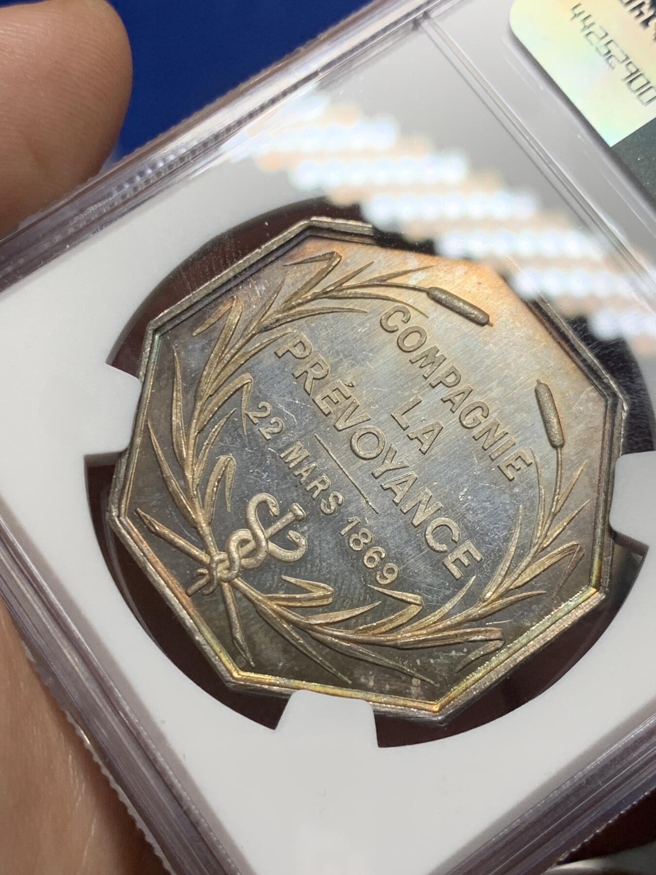 《竞宝斋》第285场- 周日，周一 2场连拍 （全场包邮） NGC MS61 法国1869年先见之明保险公司银质八角代币 名誉品 海港 优雅女神 神明庇护 出海帆船 盆满钵满的金银 36.3毫米 19.13克 蜜蜂边铭 低评 状态非常好