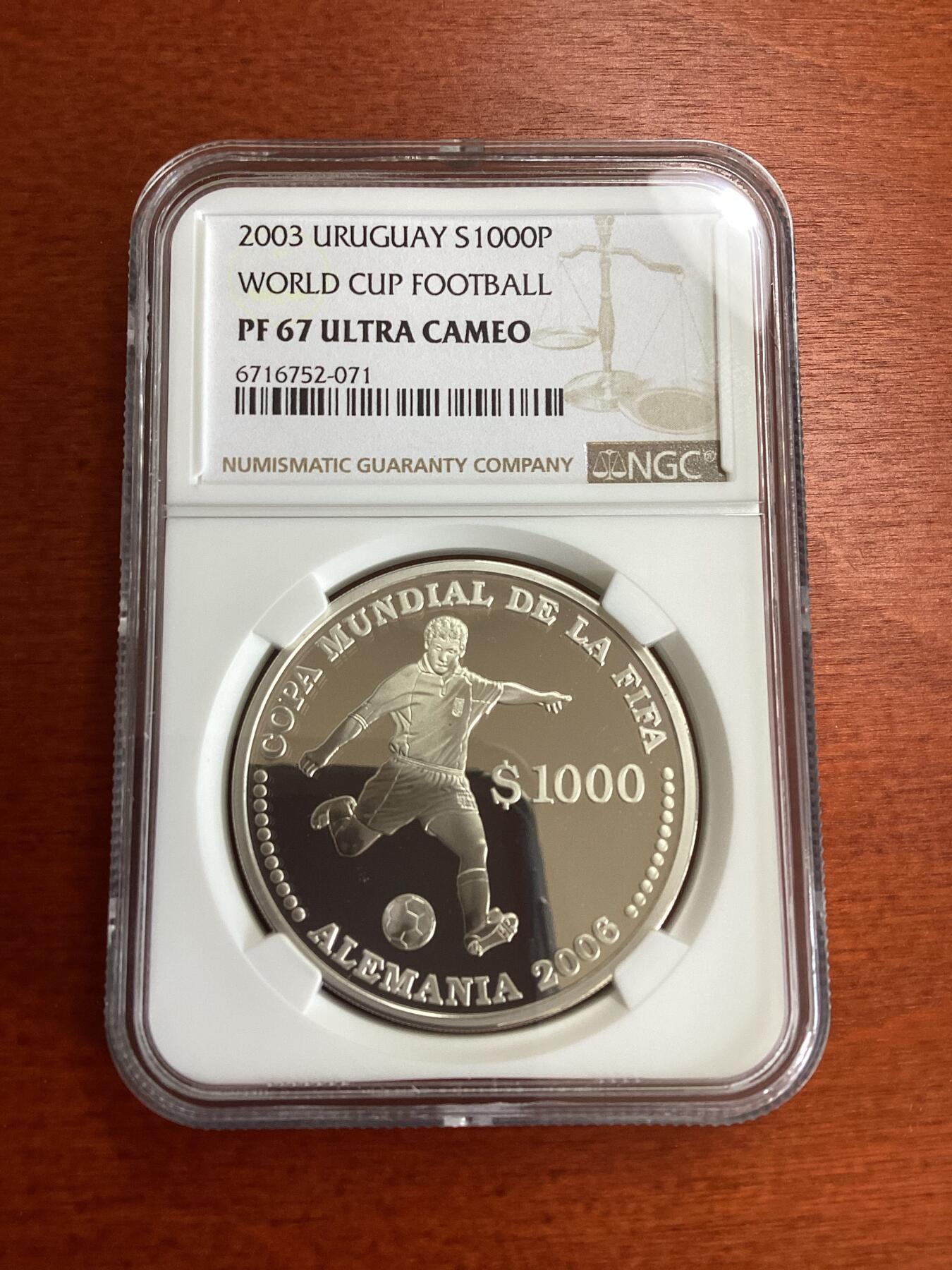 长老汇龙年精选第九场拍卖 2003 乌拉圭2006德国世界杯三枚套币之三踢球1000比索精制银币，NGC PF67UC，唯一季军分，更高分3枚