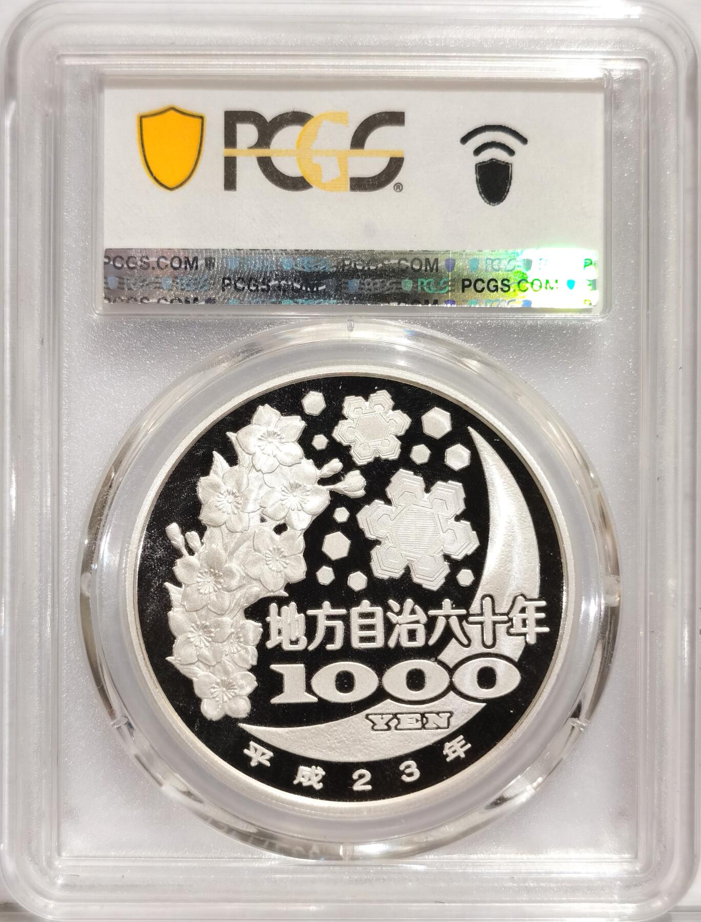 博洋堂世界钱币拍卖第084期（全场包邮） 日本2011年地方自治法施行六十周年纪念熊本县1000日元精制银币PCGS-PR69DCAM，直径40mm，重31.1g，999银，发行量10万枚。PROOF彩绘精制币，币面清爽干净又漂亮，状态极佳。注：盒子正面左下有一处小磕未掉