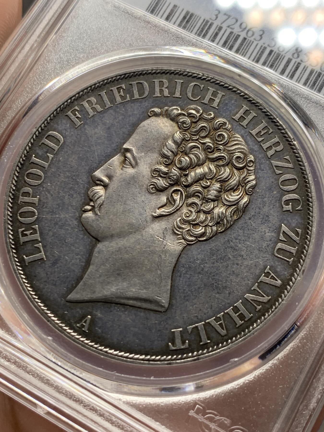 《竞宝斋》第289场- 周日，周一，周二 3场连拍 （全场包邮） PCGS AU58 德国 安哈尔特-德绍双协定泰勒 重37.12g 直径40.8mm 含银90% 正面是安哈尔特利奥波德.腓特烈公爵头像，头像上有一圈德文，其意为“安哈尔特利奥波德.腓特烈公爵”，下标A表示是柏林铸币厂制造；背面“2 THALER VII EINE F.MARK 3 1/2 GLUDEN VEREINS MÜNZE 1846