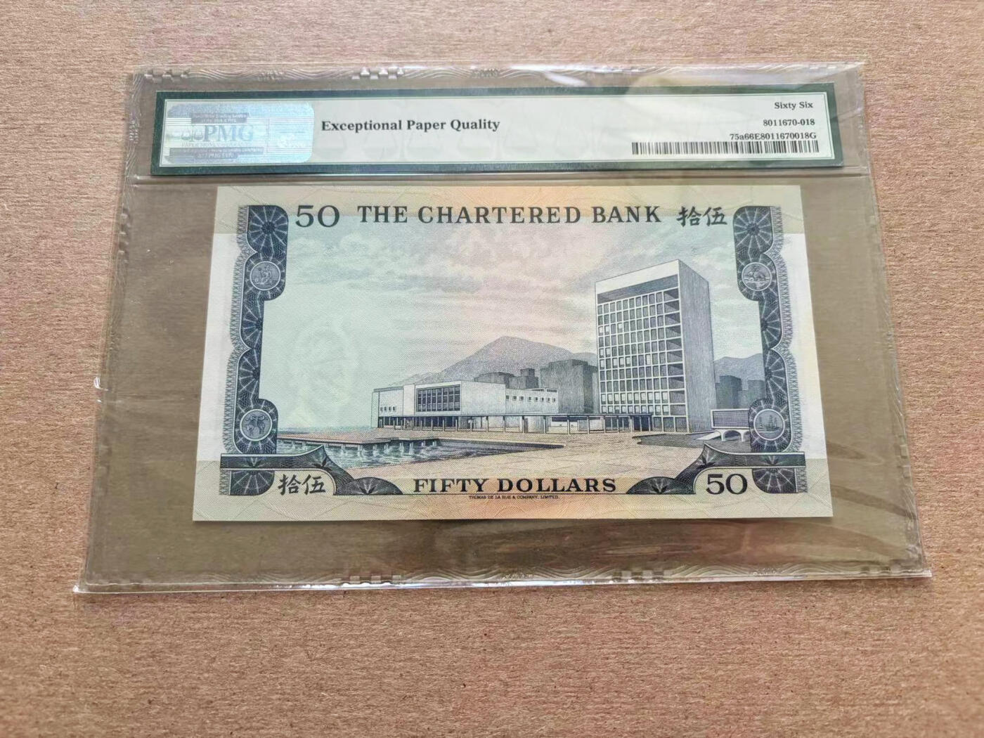 【Blue Auction】✨世界纸币精拍第510期【精】  香港 渣打 1970-75年 PMG66EPQ  此钞设计华美，压花深峻有力，构成了诱人万分的外观，备受追捧。不论是左方的银行大厦图案，中央处的盾徽，还是对比鲜明的色调，都使得此钞相当突出。背面美观悦目的大会堂图案被细节丰富的边框所包围。