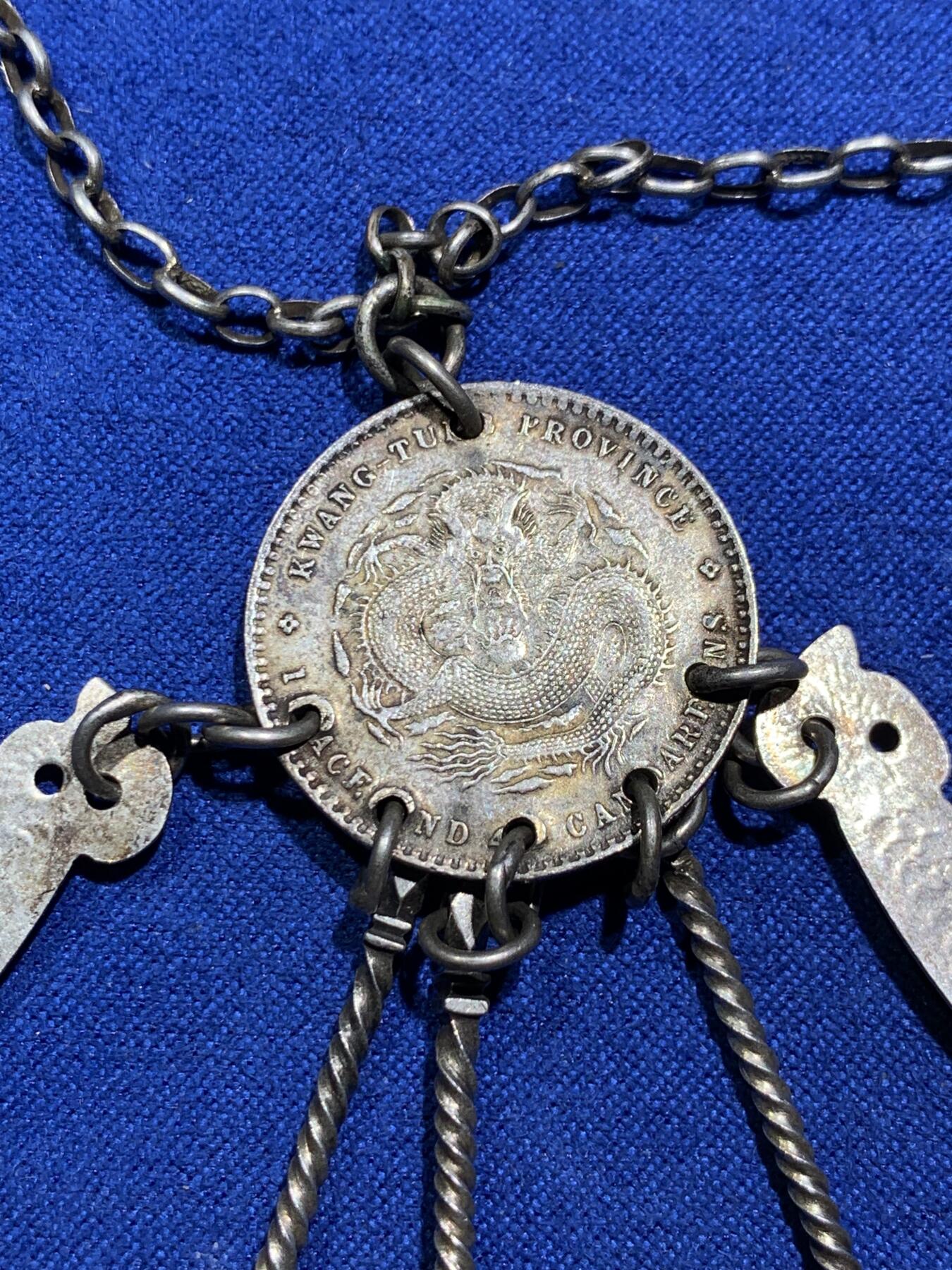 《竞宝斋》第290场- 周日，周一，周二 3场连拍 （全场包邮） 民国时期银质压襟，带泰昌银楼戳记，由广东光绪元宝改制而成非常稀少和漂亮，下挂银剑银刀银扇挖耳勺和银针 22克