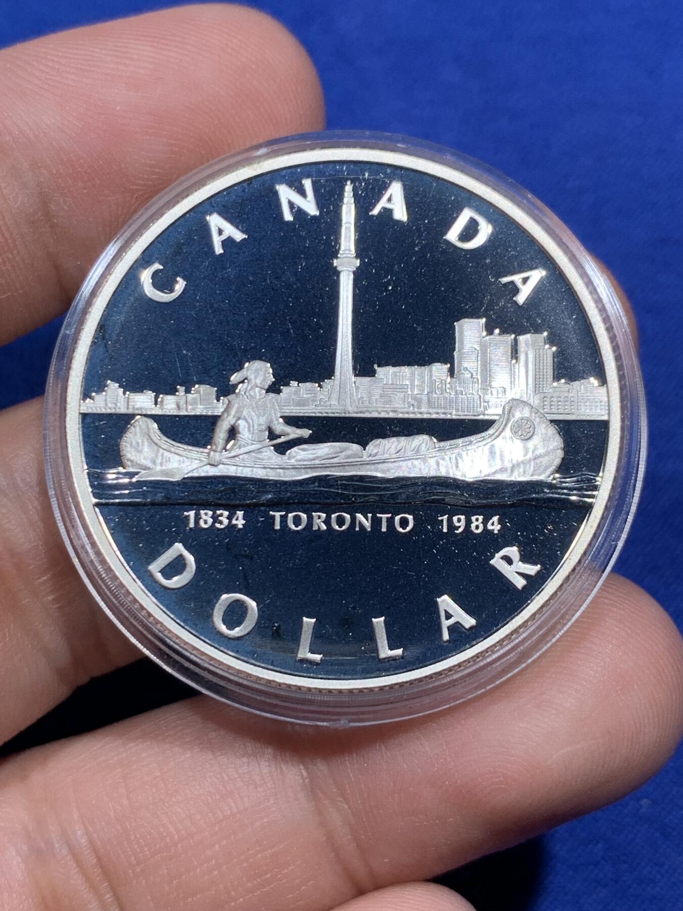 《竞宝斋》第290场- 周日，周一，周二 3场连拍 （全场包邮） 1984年加拿大多伦多市成立100周年纪念精制银币 正面为伊丽莎白二世女王年轻时右向胸像 背面为水面划船的印第安人背景为多伦多轮廓