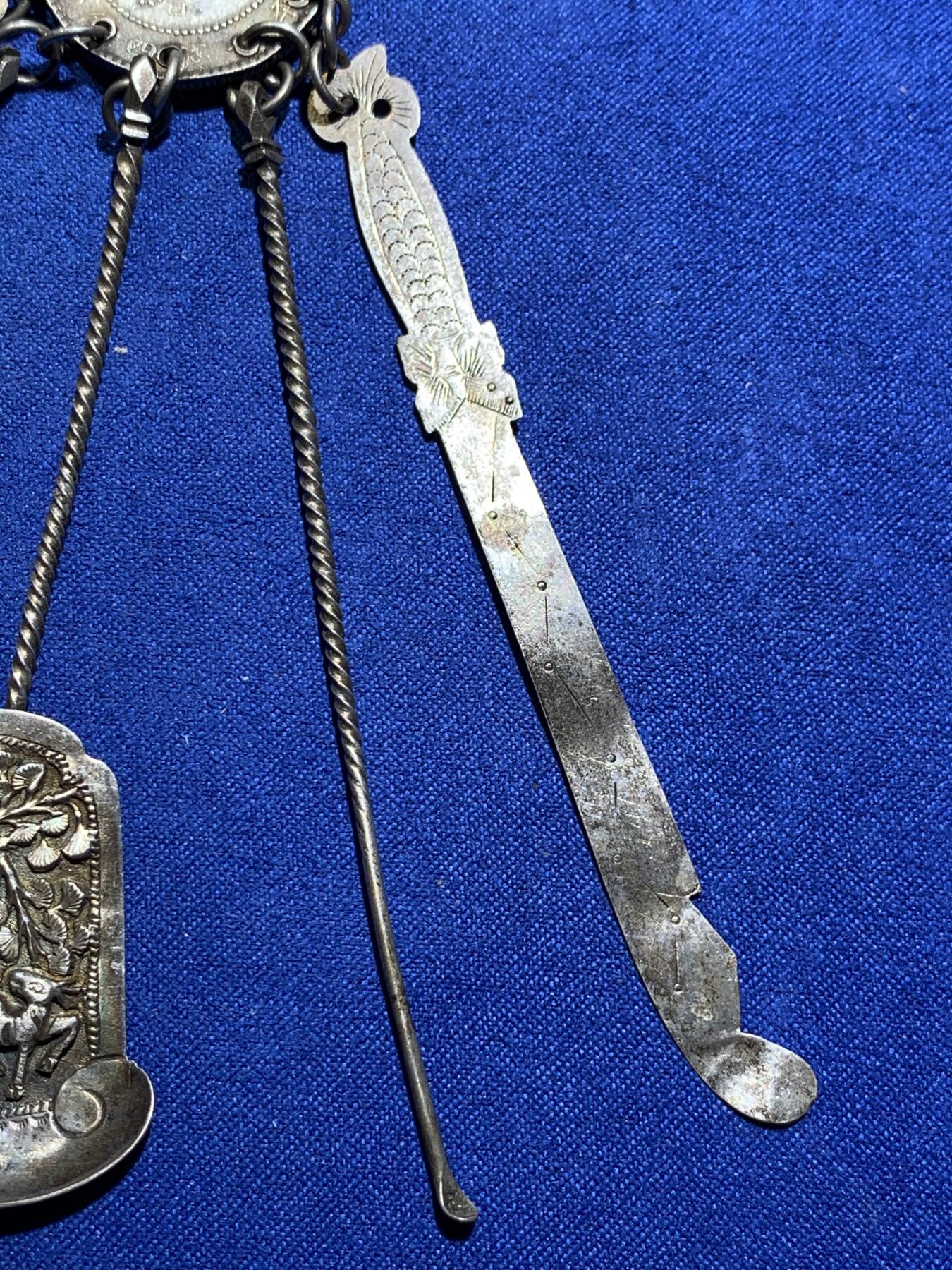 《竞宝斋》第290场- 周日，周一，周二 3场连拍 （全场包邮） 民国时期银质压襟，带泰昌银楼戳记，由广东光绪元宝改制而成非常稀少和漂亮，下挂银剑银刀银扇挖耳勺和银针 22克