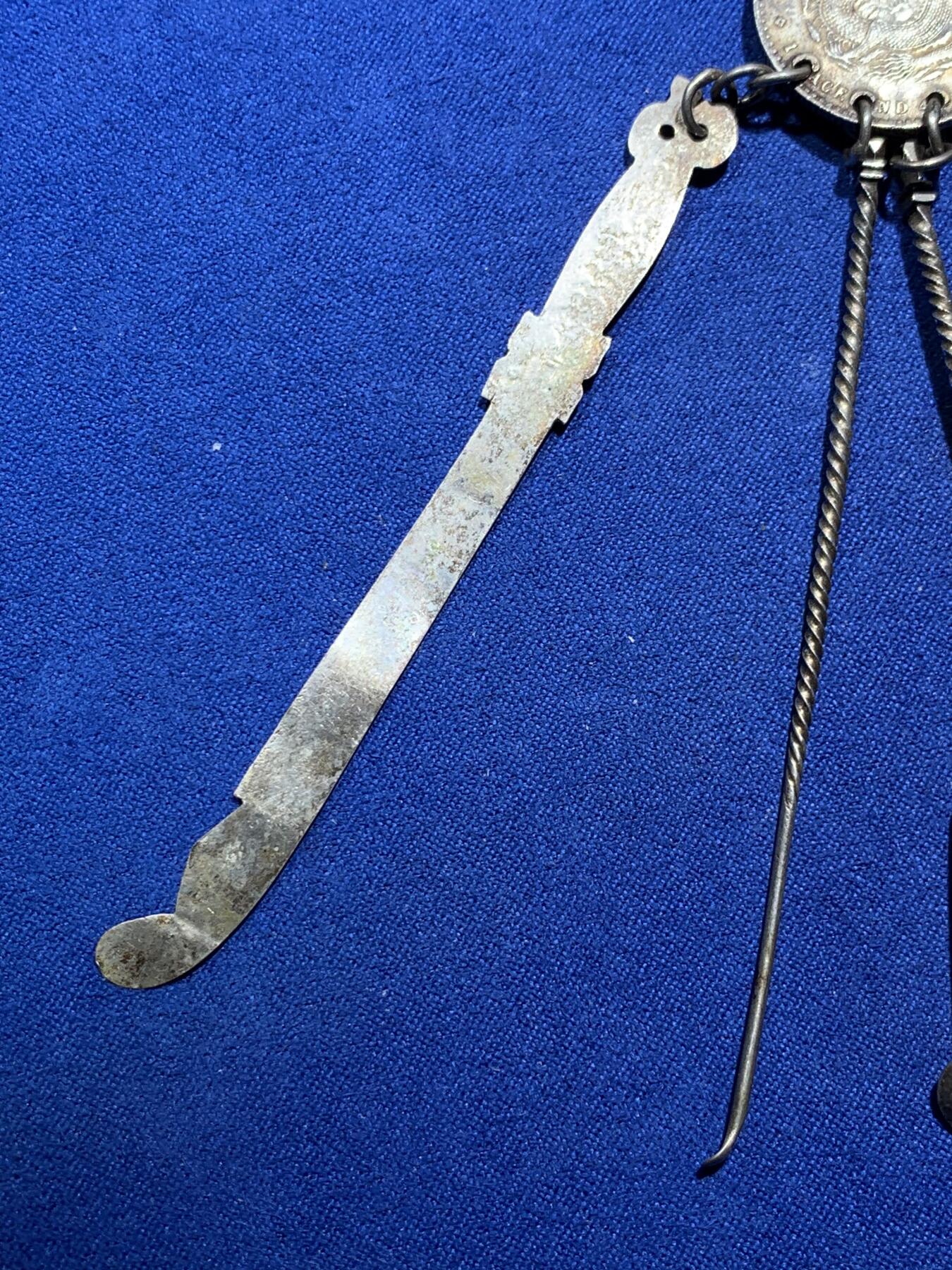 《竞宝斋》第290场- 周日，周一，周二 3场连拍 （全场包邮） 民国时期银质压襟，带泰昌银楼戳记，由广东光绪元宝改制而成非常稀少和漂亮，下挂银剑银刀银扇挖耳勺和银针 22克