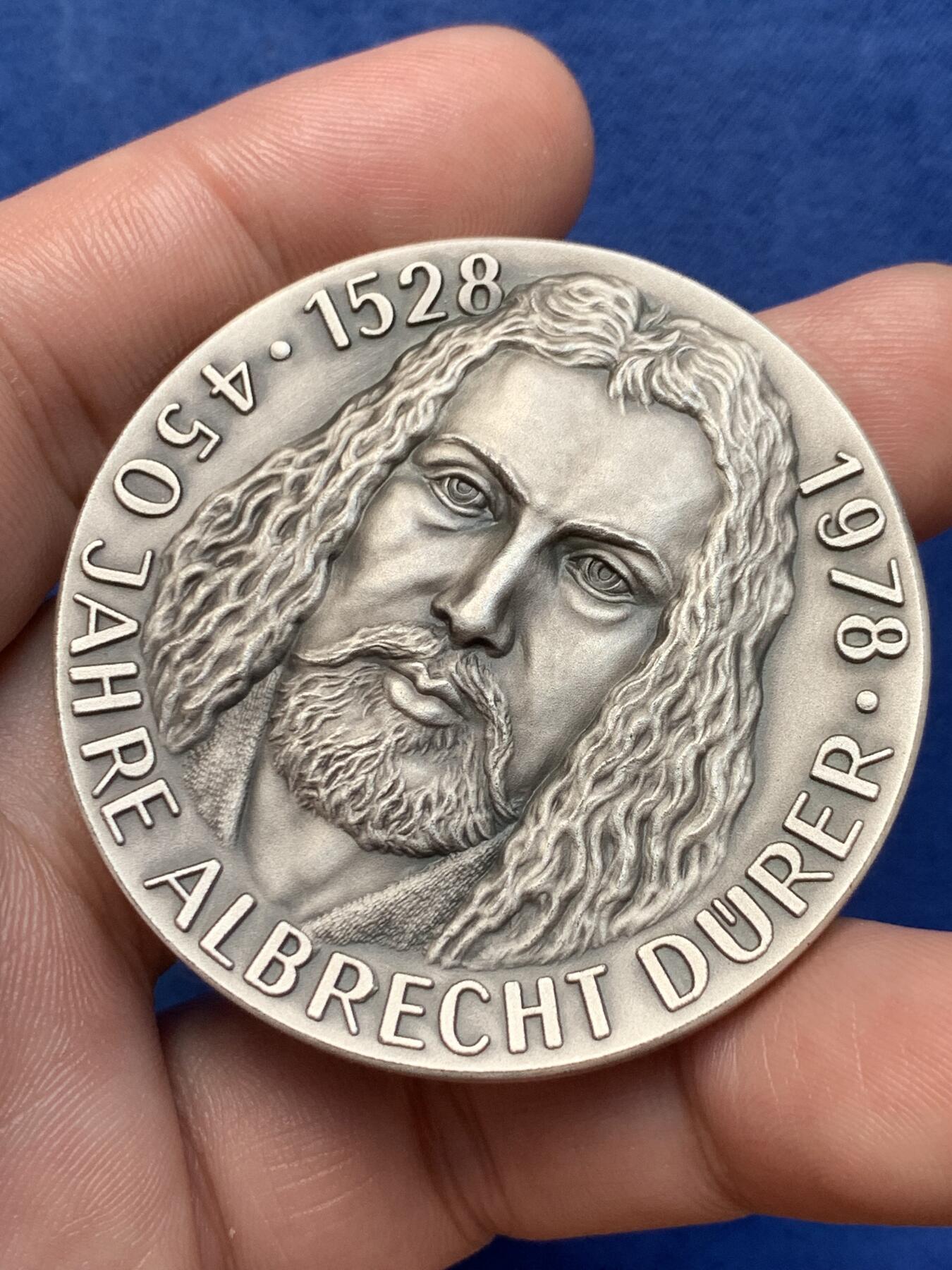《竞宝斋》第294场- 周日，周一  2场连拍 （全场包邮） 1978年德国艺术家，阿尔布雷特•丟勒（Albrecht Direr，1471年一1528年），逝世450周年银章，他生于纽伦堡，是德国著名画家、版画家及木版画设计家。直径49.5mm；纯银；重60,65克。主要作品有《启示录》《基督大难》《小受难》《祈祷之手》《男人浴室》《海》《浪荡子》《伟大的命运》《亚当与夏娃》和《骑士、死神与魔鬼》等