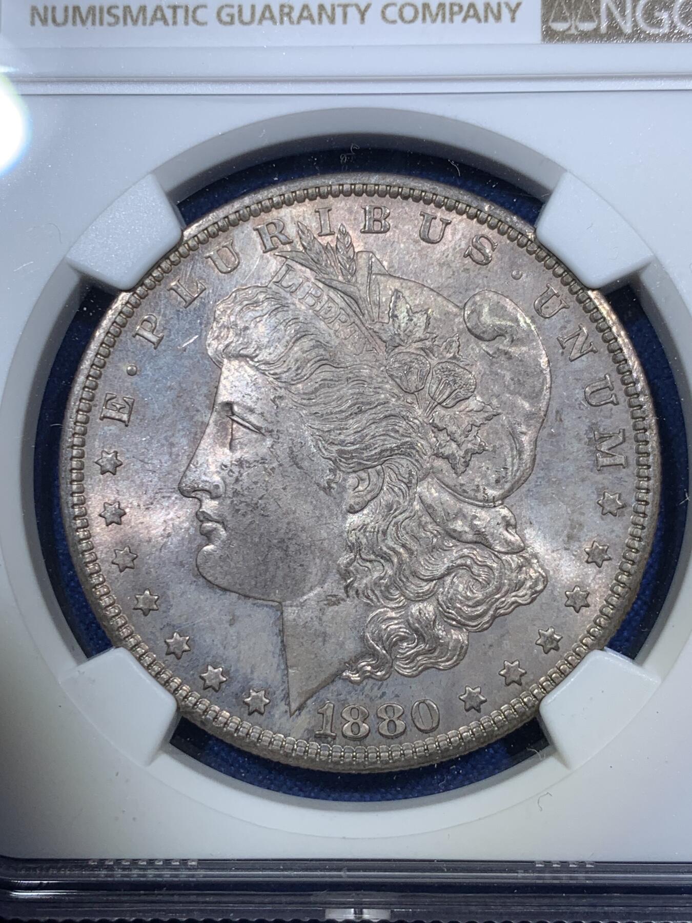 《竞宝斋》第294场- 周日，周一  2场连拍 （全场包邮） NGC MS64 美国1880-S 摩根1美元银币 一颗到位的1880年摩根，该特有的镜面底板，配合正面五彩包浆非常亮眼，尤其是背面带有一抹绚丽彩虹，摩根标准器，错过要后悔的状态。