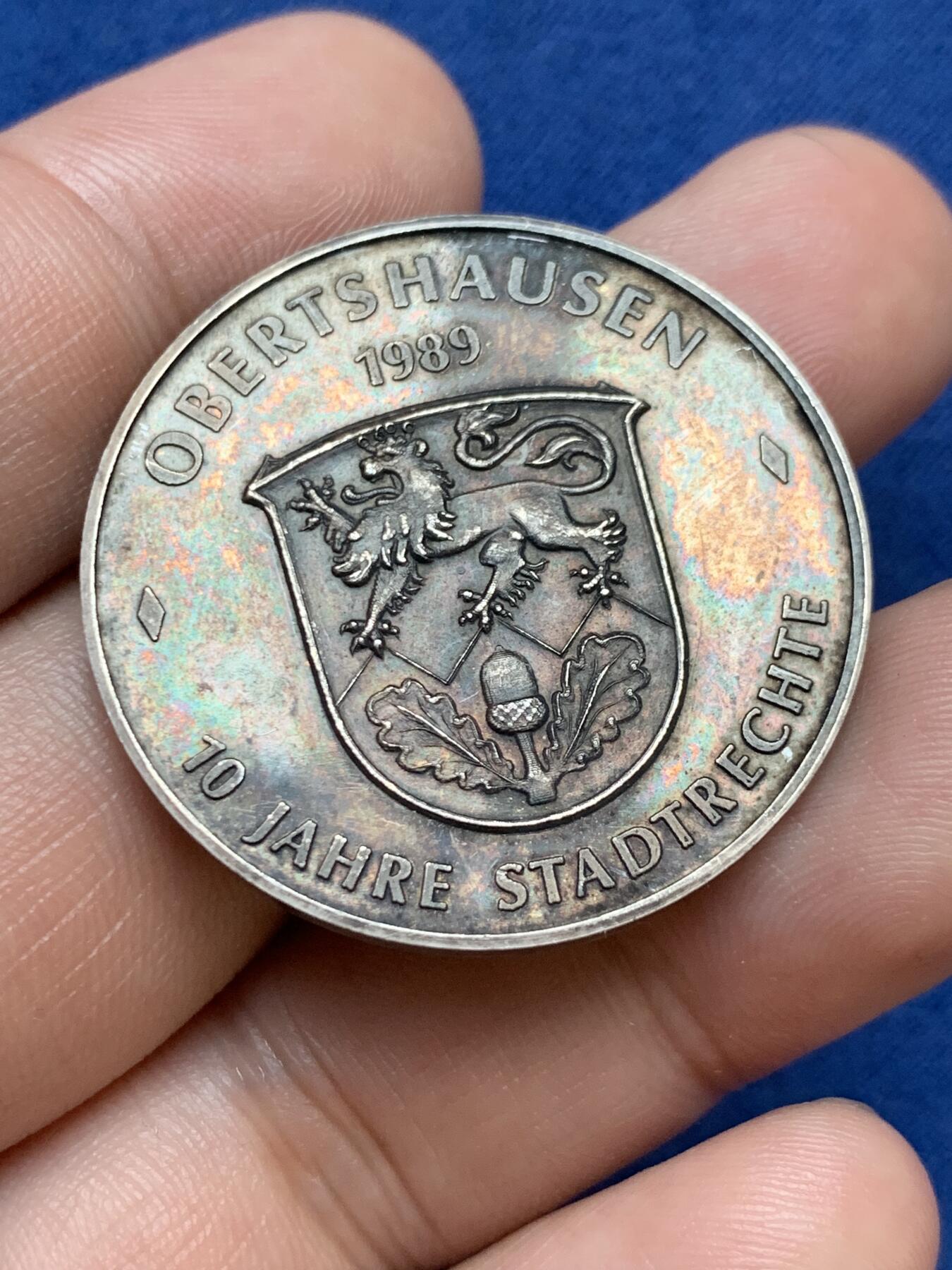 《竞宝斋》第295场- 周日，周一  2场连拍 （全场包邮） 德国奥伯茨豪森银章 1989年城市法律成立70周年 正面为城市会长，背面为城市景观，首见品，直径35mm、重14.82克