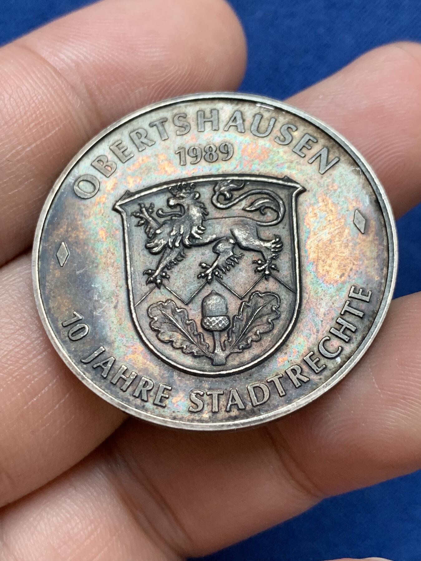 《竞宝斋》第295场- 周日，周一  2场连拍 （全场包邮） 德国奥伯茨豪森银章 1989年城市法律成立70周年 正面为城市会长，背面为城市景观，首见品，直径35mm、重14.82克