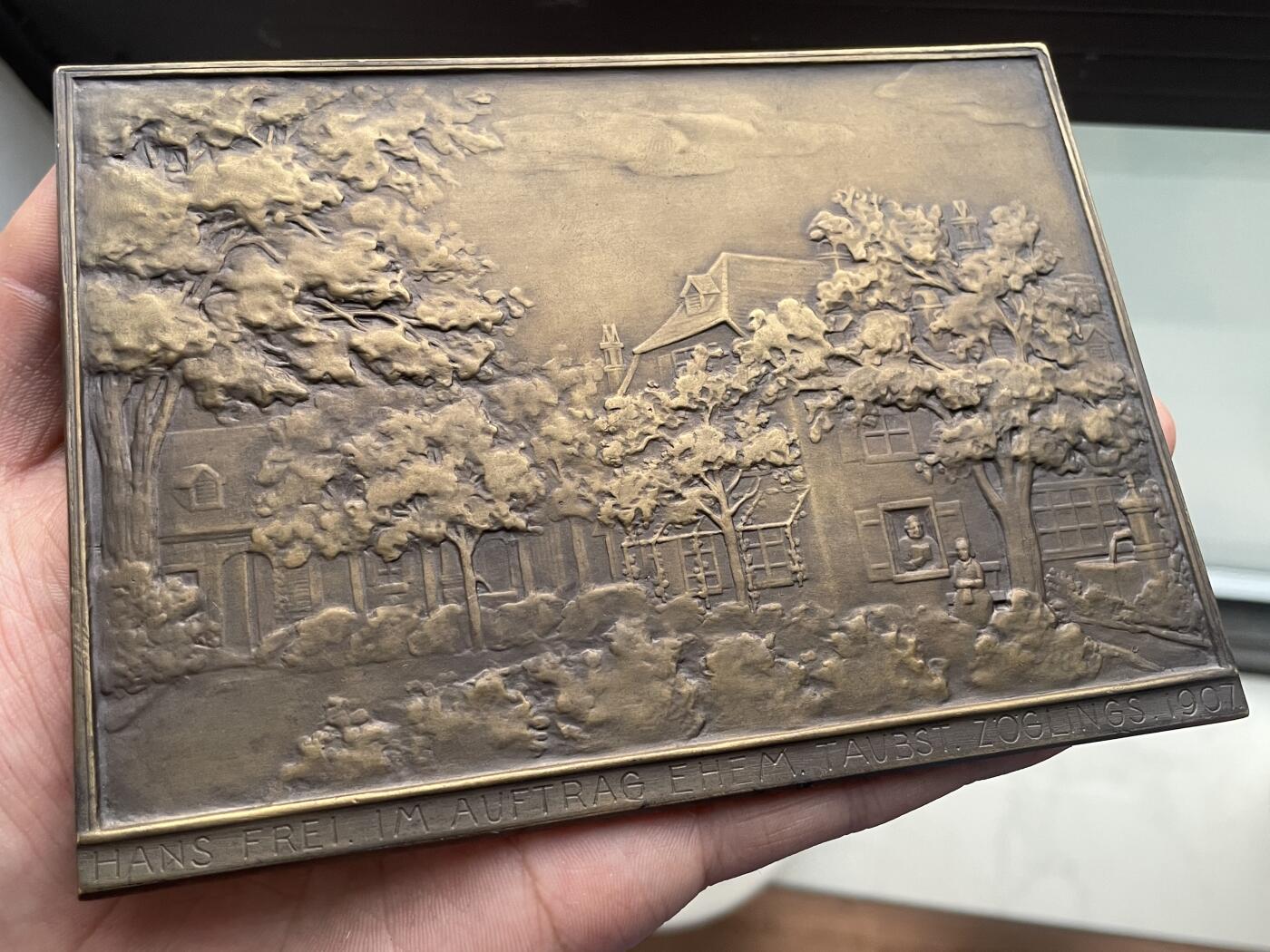 「木头集藏」章牌精品专场！ Hans Frei～1907年瑞士致敬恩师阿诺德夫妇大型双面矩形浇铸铜章，尺寸：139×100mm，404g，罕见品种。这么大尺寸的双面矩形浇铸铜章在当时就很罕见。由瑞士里恩聋哑人机构的学生集资委托铸造，献给他们的校监威廉·阿诺德（Wilhelm Daniel Arnold）及其妻子多萝西娅 。正面是阿诺德夫妇的半身像，背面是阿诺德夫妇置身于绿树掩映的校舍里。