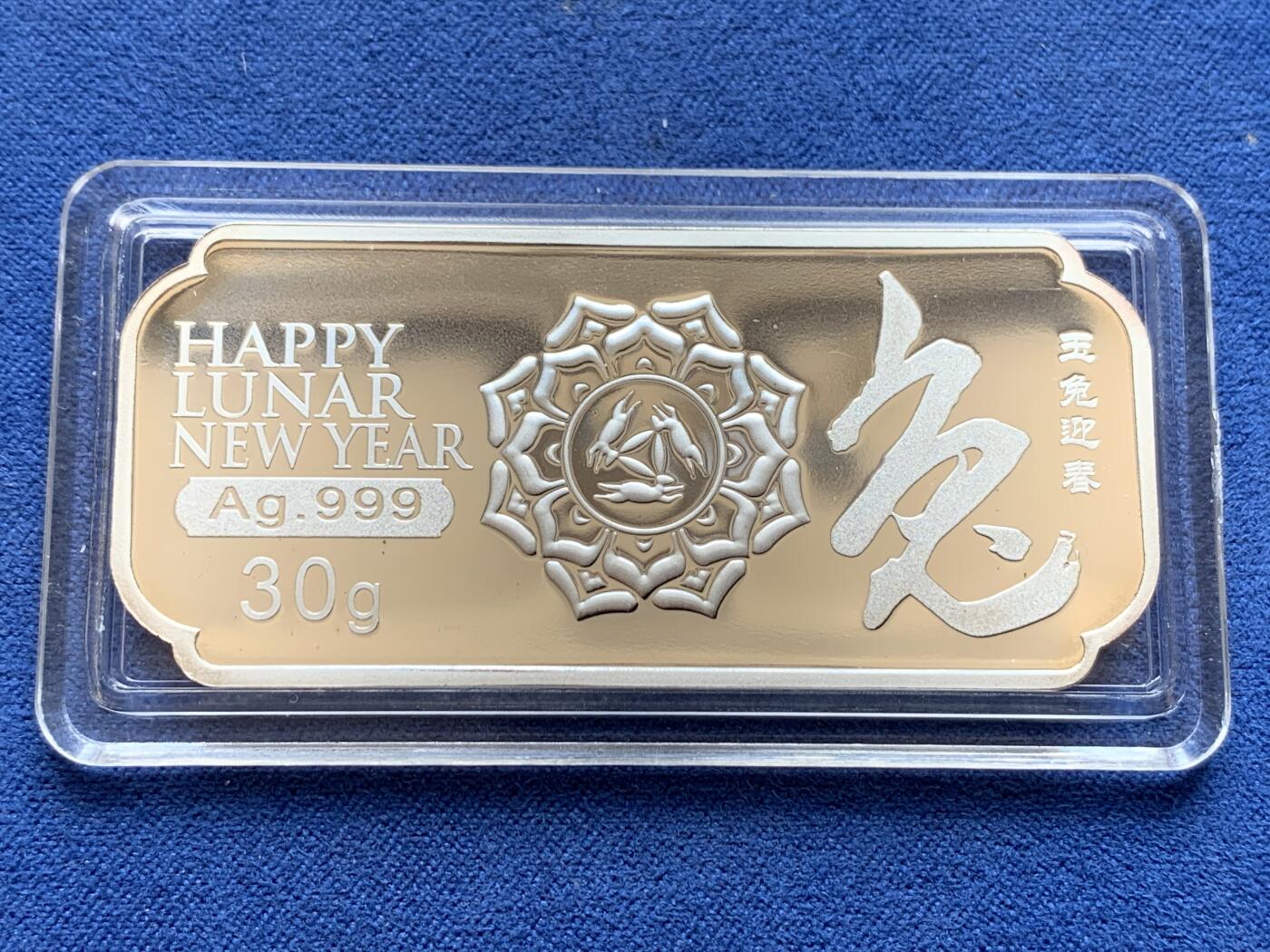 《竞宝斋》第297场- 周日，周一  2场连拍 （全场包邮） 彩银 2011年 中国 上海造币厂 兔年 30克大银条，最近银价7左右，一面是可怜的兔子和两只私奔月亮的玉兔，彩色兔子后面的牡丹花很立体，一面是体现上海接轨国际化lunar的新春快乐，花朵内部花蕊三只兔子围绕一起，有点曼岛的三条腿的感觉。