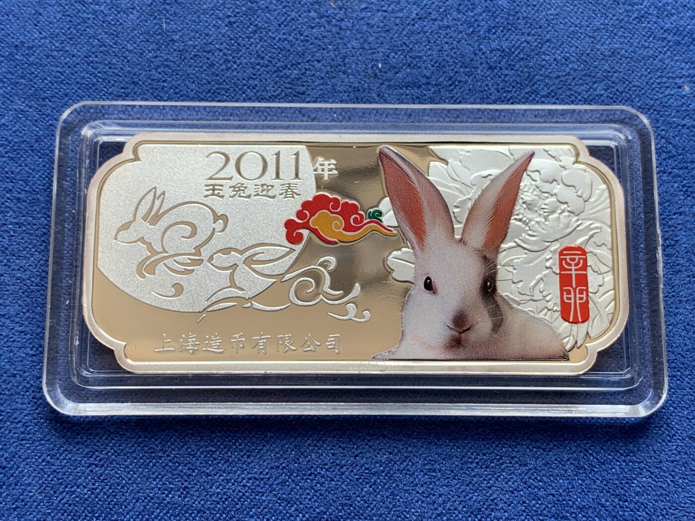 《竞宝斋》第297场- 周日，周一  2场连拍 （全场包邮） 彩银 2011年 中国 上海造币厂 兔年 30克大银条，最近银价7左右，一面是可怜的兔子和两只私奔月亮的玉兔，彩色兔子后面的牡丹花很立体，一面是体现上海接轨国际化lunar的新春快乐，花朵内部花蕊三只兔子围绕一起，有点曼岛的三条腿的感觉。