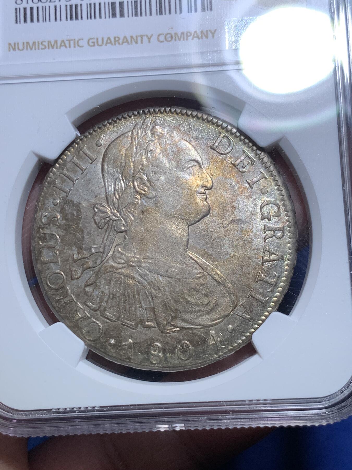 《竞宝斋》第298场- 周日，周一  2场连拍 （全场包邮） NGC AU58 玻利维亚1804年卡洛斯四世8里亚尔银币 高点细节具在，底板几近无痕 光感强烈 币面环状五彩黄油光包浆 非常漂亮，严重低评的一枚
