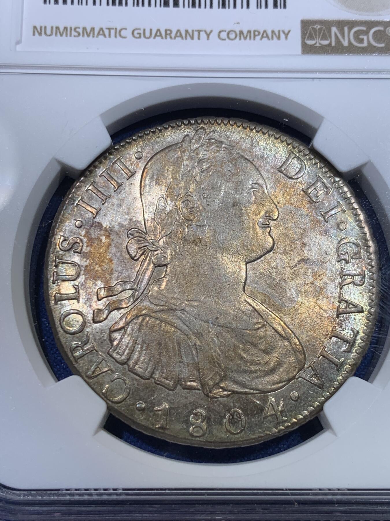 《竞宝斋》第298场- 周日，周一  2场连拍 （全场包邮） NGC AU58 玻利维亚1804年卡洛斯四世8里亚尔银币 高点细节具在，底板几近无痕 光感强烈 币面环状五彩黄油光包浆 非常漂亮，严重低评的一枚
