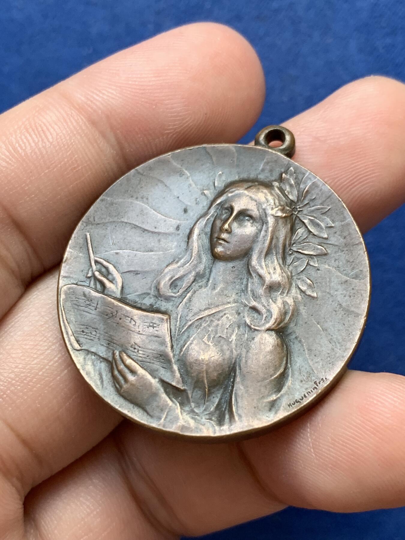 《竞宝斋》第299场- 周日，周一  2场连拍 （全场包邮） 瑞士1903年音乐节铜奖章，女神手里纸卷印有五线谱，4点钟方向是作者签名 带吊环高39.5mm 25.4克 高浮雕