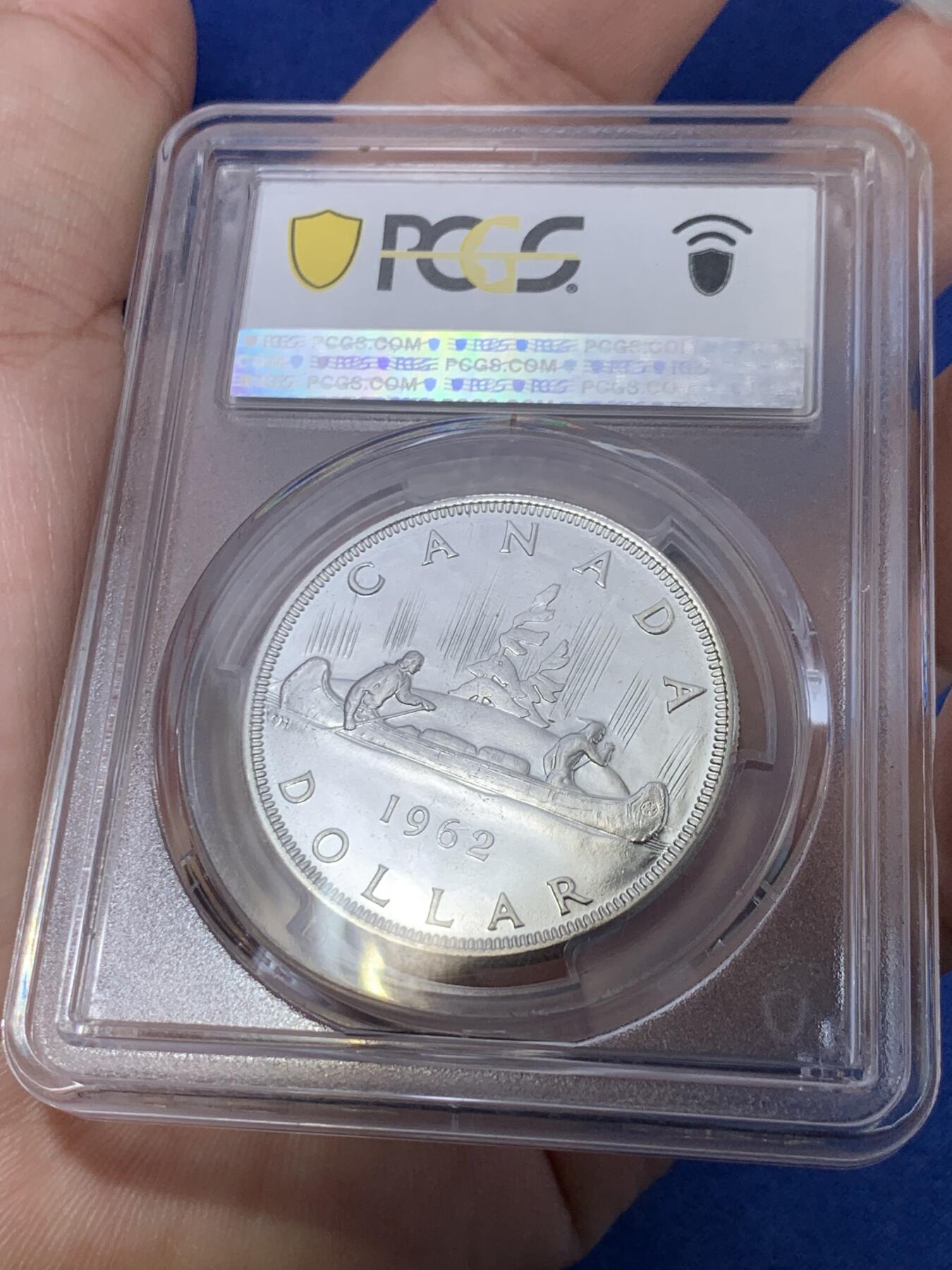 《竞宝斋》第299场- 周日，周一  2场连拍 （全场包邮） PCGS PL66 加拿大1962年独木舟划船1元银币 币面清爽干净又漂亮，类镜面效果，伊丽莎白二世青年头像，经典原住民划船图案，图案精美。