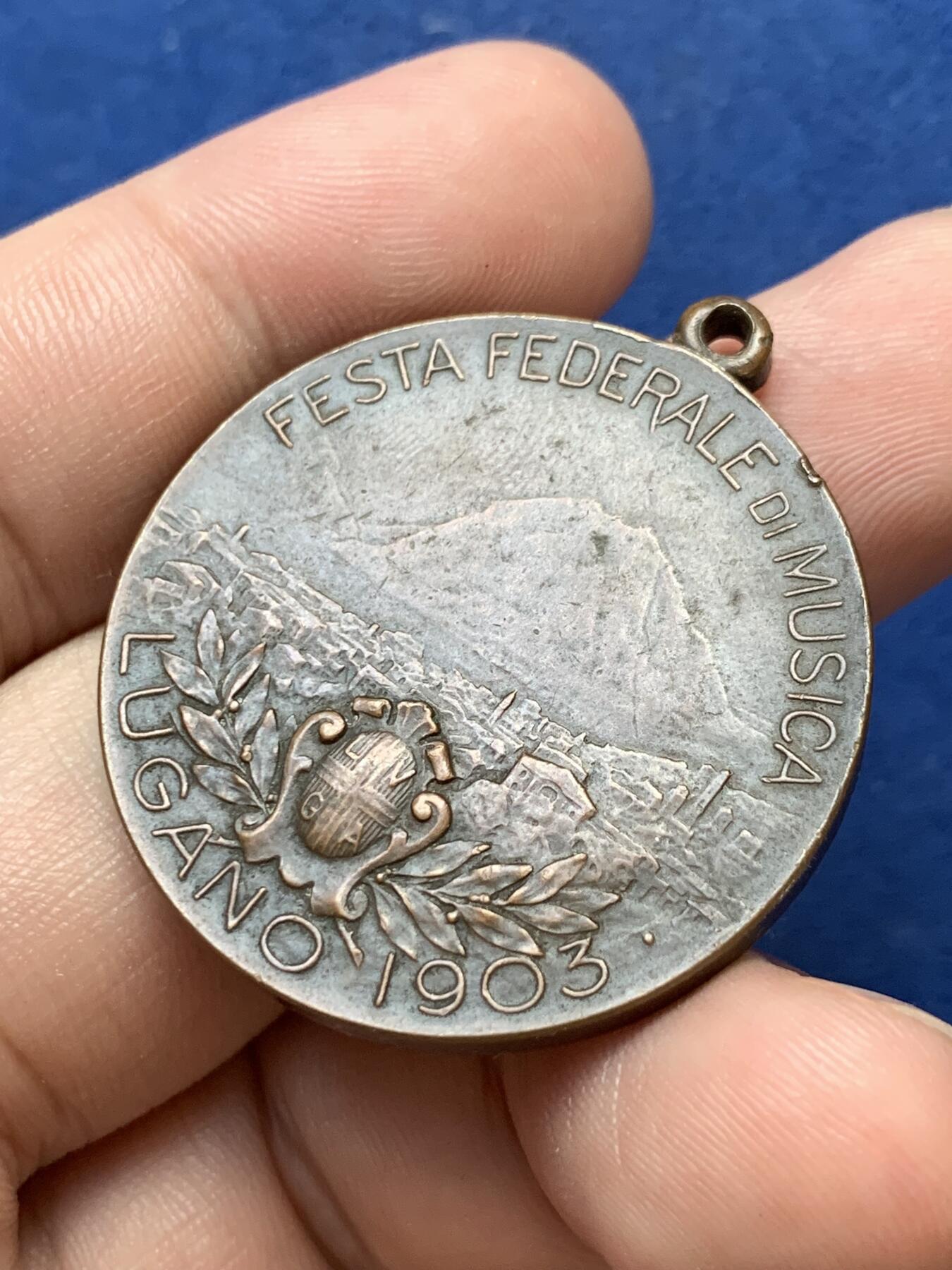 《竞宝斋》第299场- 周日，周一  2场连拍 （全场包邮） 瑞士1903年音乐节铜奖章，女神手里纸卷印有五线谱，4点钟方向是作者签名 带吊环高39.5mm 25.4克 高浮雕