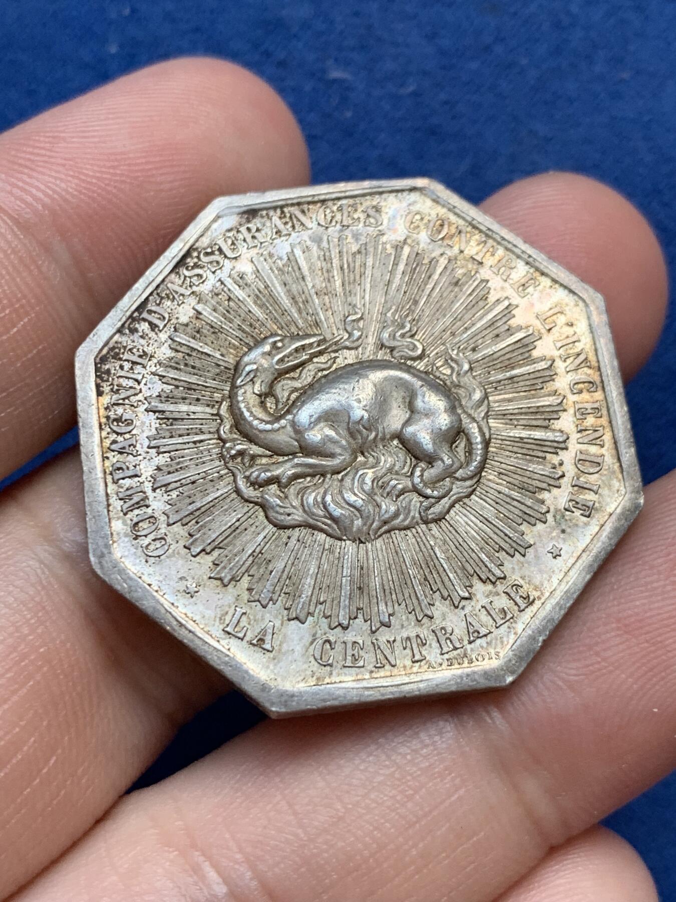 《竞宝斋》第299场- 周日，周一  2场连拍 （全场包邮） 法国1863中央保险公司八角银质代币 小名誉品放射龙 19.96g 34.6mm 丰饶角边铭 五彩包浆