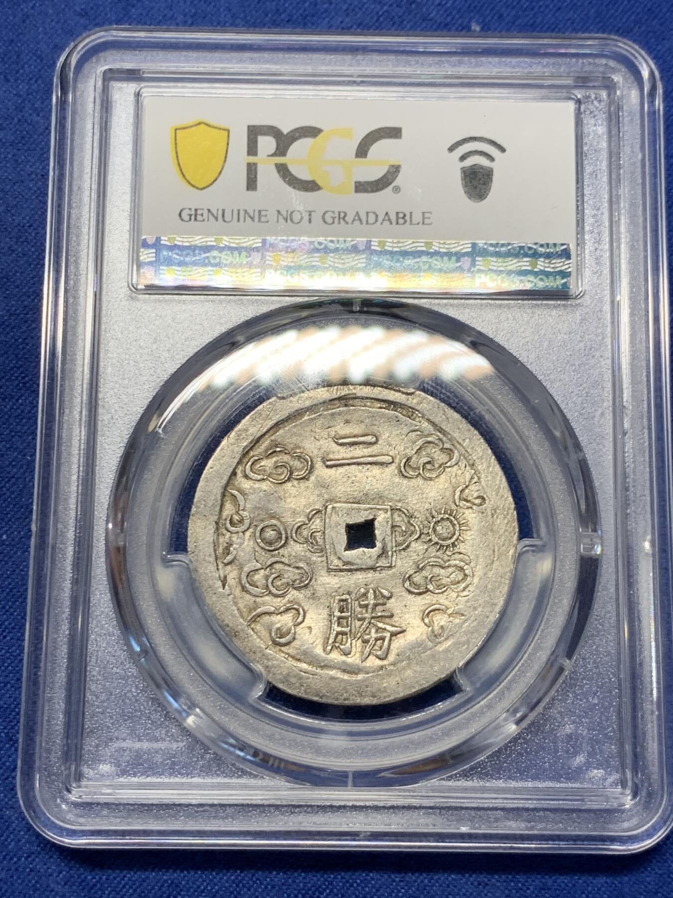 《竞宝斋》第299场- 周日，周一  2场连拍 （全场包邮） PCGS-UNCD 安南嗣德通宝1848-83年日月二胜银币 原味包浆，图案文字深打，低评状态，各大拍卖二钱所见尽是“二仪“，PC记录中入盒二胜非常罕见，因而本枚被归纳入二仪的编号下，可能是该设计最终未被选定， 凤毛麟角的存世珍品，MS底板，建议重评博分