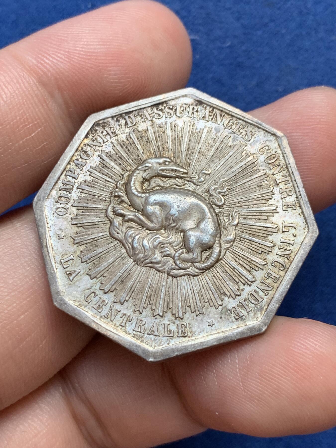 《竞宝斋》第299场- 周日，周一  2场连拍 （全场包邮） 法国1863中央保险公司八角银质代币 小名誉品放射龙 19.96g 34.6mm 丰饶角边铭 五彩包浆