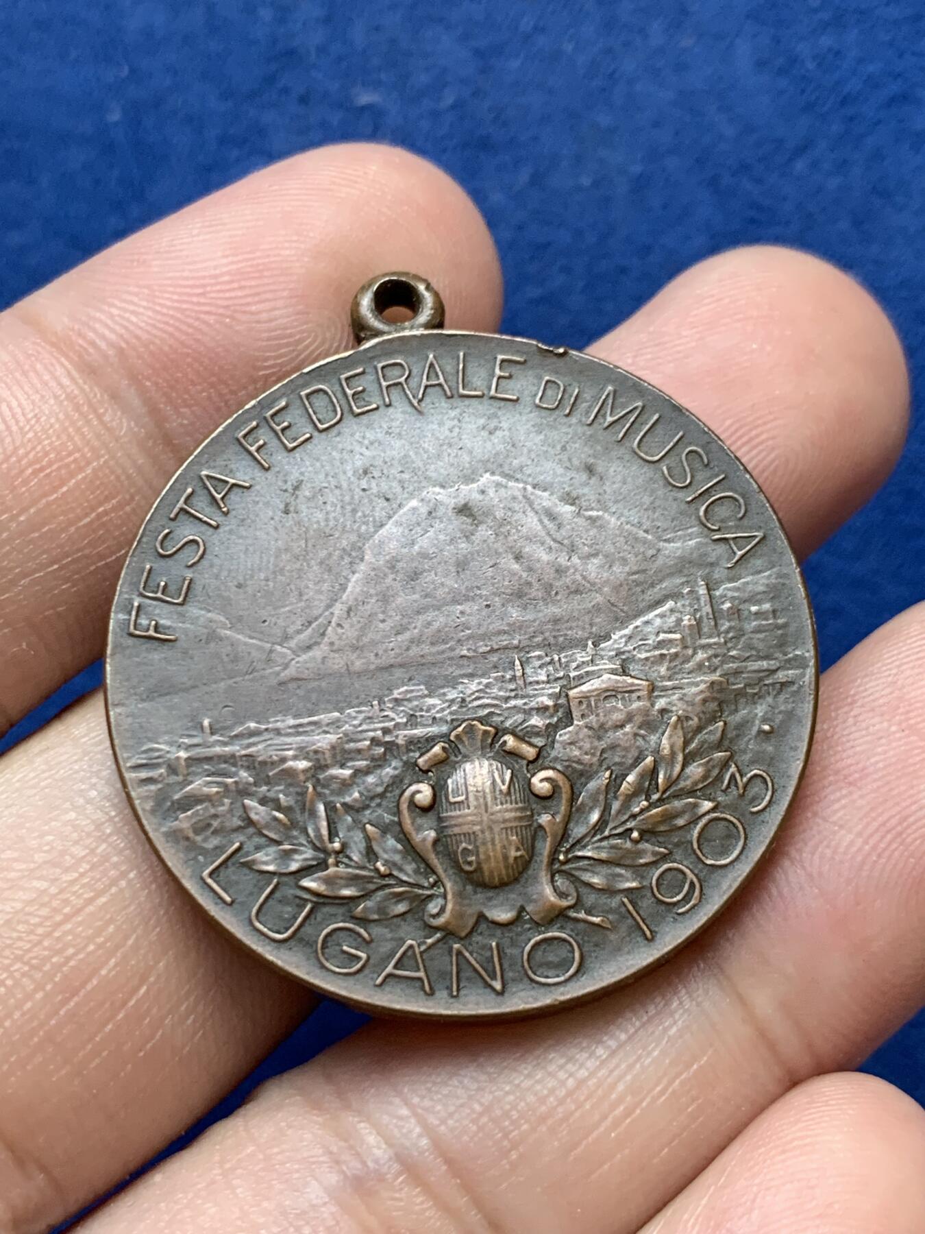 《竞宝斋》第299场- 周日，周一  2场连拍 （全场包邮） 瑞士1903年音乐节铜奖章，女神手里纸卷印有五线谱，4点钟方向是作者签名 带吊环高39.5mm 25.4克 高浮雕