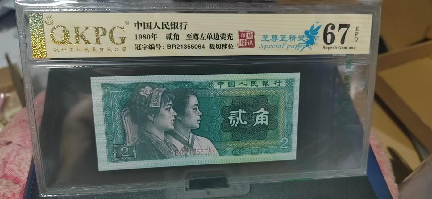 周六纸币+古币拍场 钱坤评级  8002  至尊左单边荧光、至尊蓝精灵、印刷错误、裁切移位，BR21355064，8002荧光版别中的王者！早期第一大组冠号，能评到67分十分难得，这种顶级货很少有人上拍了，希望大家珍惜！金标