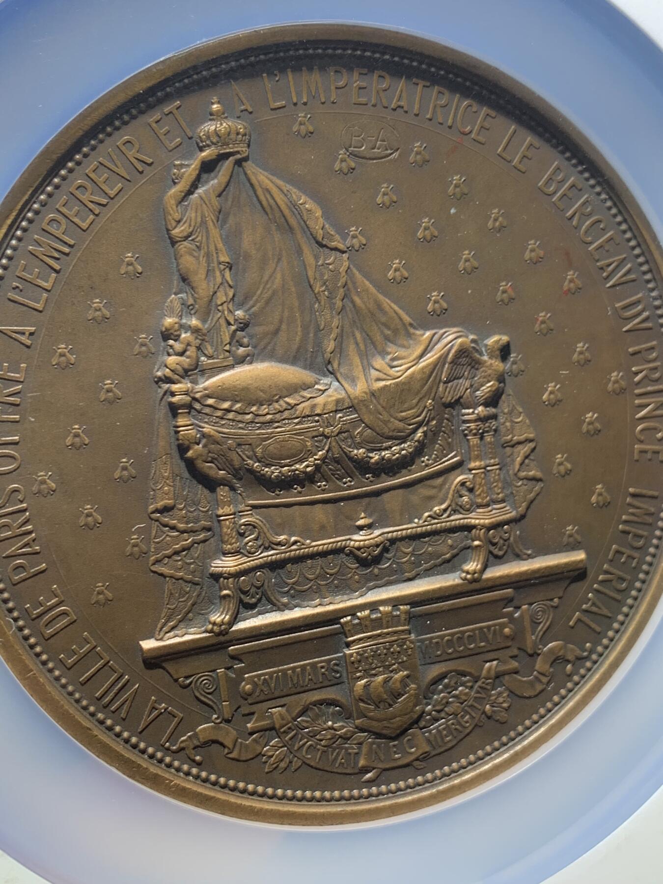 《竞宝斋》第302场- 周日，周一，周二  3场连拍 （全场包邮） NGC UNCD 1856年巴黎市庆祝拿破仑三世皇子诞生原铸纪念铜章，正面6:00、背面：13:00方向加私印BA标记，章表面无任何问题，完美品相。丰饶角边铭，直径：77.5mm、重：235.32克 正面画面为拿破仑三世刚刚诞生的皇子安然的睡在摇篮中 法兰西雄鹰伸展双翅保护皇子 巴黎的两位守护天使在上方祝福皇子，背面的画面为巴黎市政府赠予给拿破仑三世皇子的皇室奢华婴儿床 背景遍布法国皇室的象征--