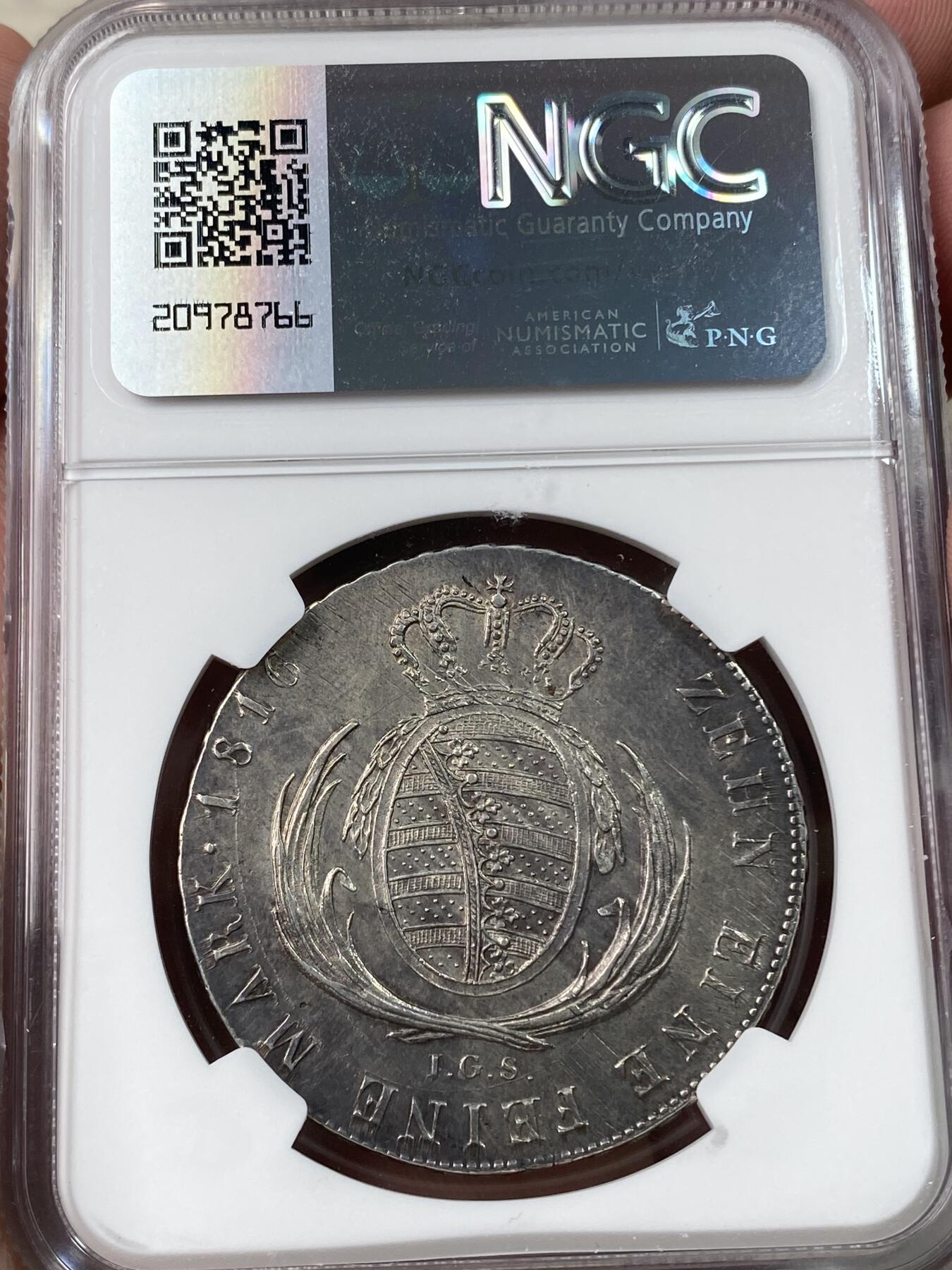 万国钱币拍卖第033期 NGC AUD 1816年德国萨克森花边协定大泰勒，重 28.0644g，纯度 83.3%，直径39mm。正面为弗雷德里克奥古斯都一世头像。背面圈铭：十枚兑一科隆马克银。此为倒数第二个发行年份，数量较为稀少，也是发行期间，唯一头像胸口位置靠近币缘的年份，俗称larger bust。