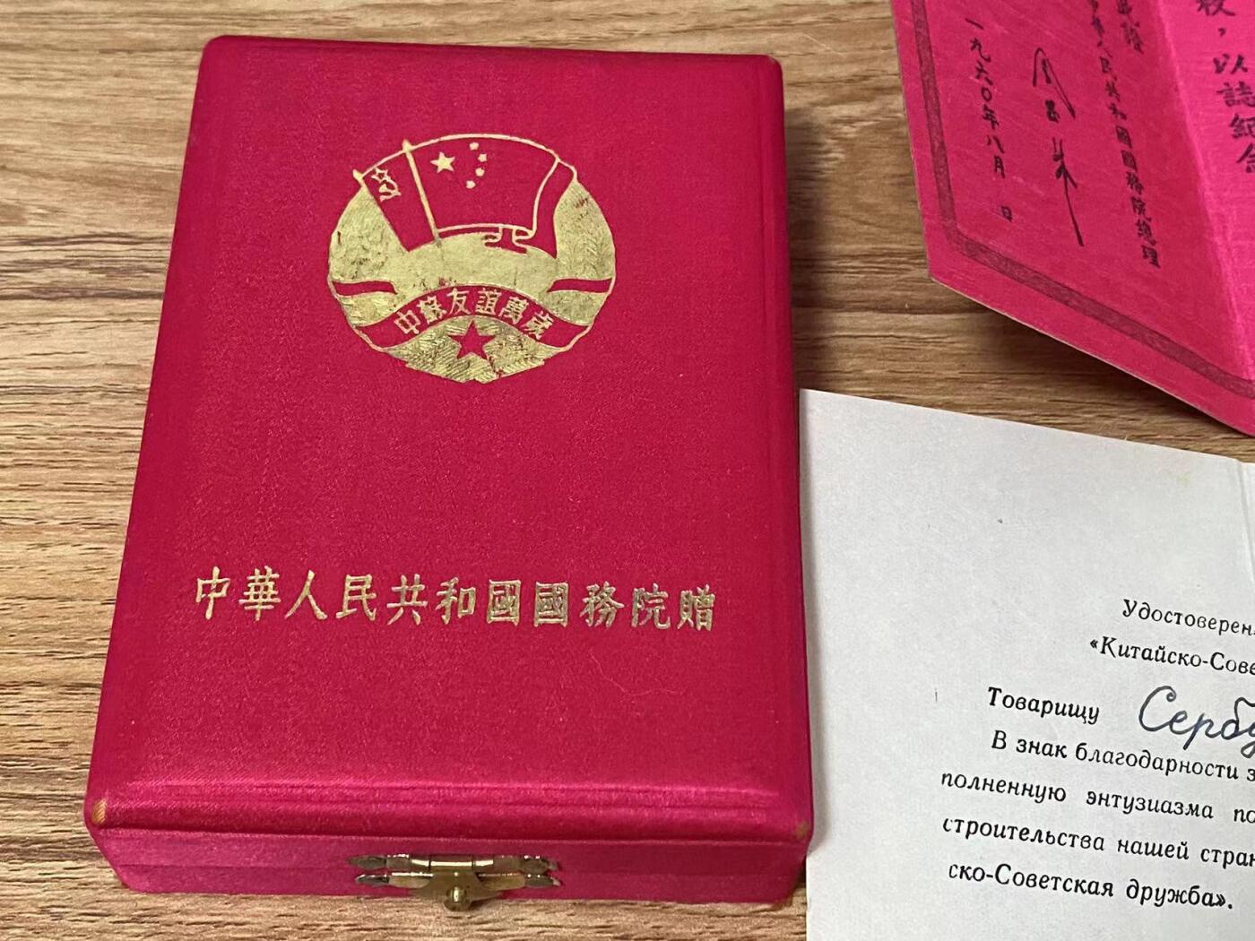 苏联勋章奖章拍卖9月20日晚上九点结束在麦稀奇 本次有佣金 中苏友谊奖章 原盒 原证件 比较少见女专家 60年总理签发比较靠后 也很少见  盒子品相很好 无破损 卡扣完好 有两处小摩擦边缘处 可以忽略 内部状态完好 无损坏 证书两本 一本中文 一张俄文齐全 无破损 状态很好 奖章珐琅无磕碰 原环 原挂 状态良好。Сербудовой З.А.