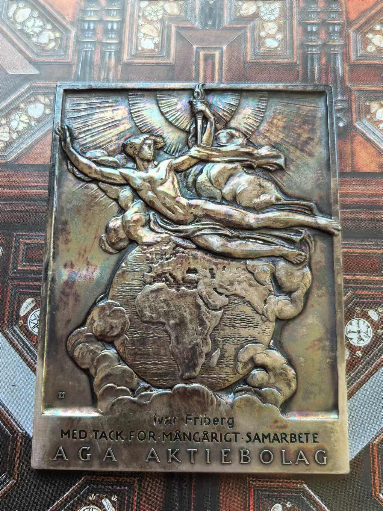 外国币章第二十五期 瑞典银章，5.5x7.5 cm，126g。Gustaf Dalén，1869年11月30日-1937年12月9日)，瑞典物理学家与发明家，研究领域为机械工程的应用。1912年因为发明结合燃点航标、燃点浮标和蓄电池等功能的自动调节装置而获得诺贝尔物理学奖。 本章正面是他的半身像，背面寓意他发现的光明照亮了地球。自带特制亚克力摆架，彩色包浆。