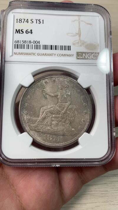 万国钱币拍卖第034期 NGC MS64 1874S美国拿花贸易银一元 曾在华广泛流通的贸易银品种，BU级别非常难得，双面均匀纸袋包浆，转光依旧，顶级收藏品相。（盒子左上角破损）