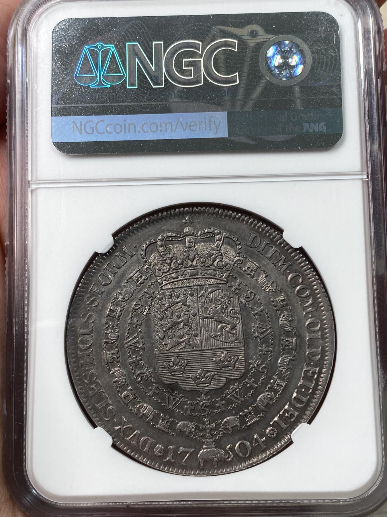 万国钱币拍卖第034期 NGC MS61 1704年丹麦弗雷德里克四世塔勒大银 极其稀有的品种，哥本哈根铸币厂造，铸造量仅309枚，双面一色老包浆，打制极佳，性感波浪卷发一览无余，斯堪的纳维亚系列藏家不可或缺的进阶品种。